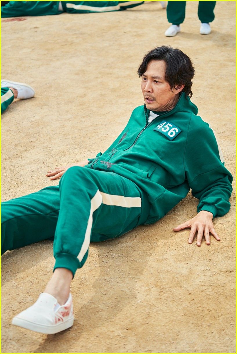 A man in a green tracksuit lying on the ground - Squid Game