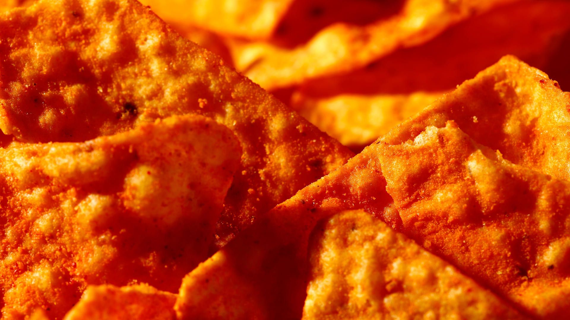 A close up of some orange chips - Doritos
