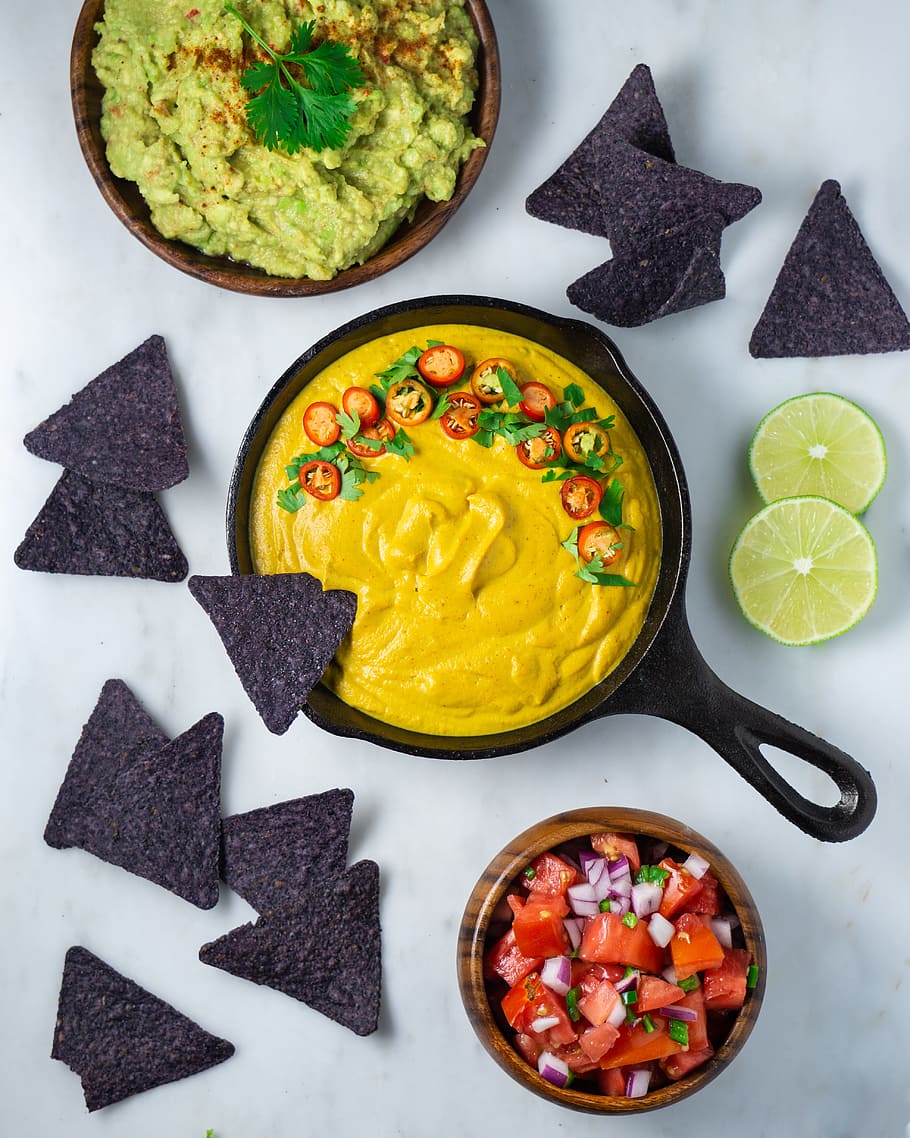 A bowl of guacamole and chips on the table - Doritos