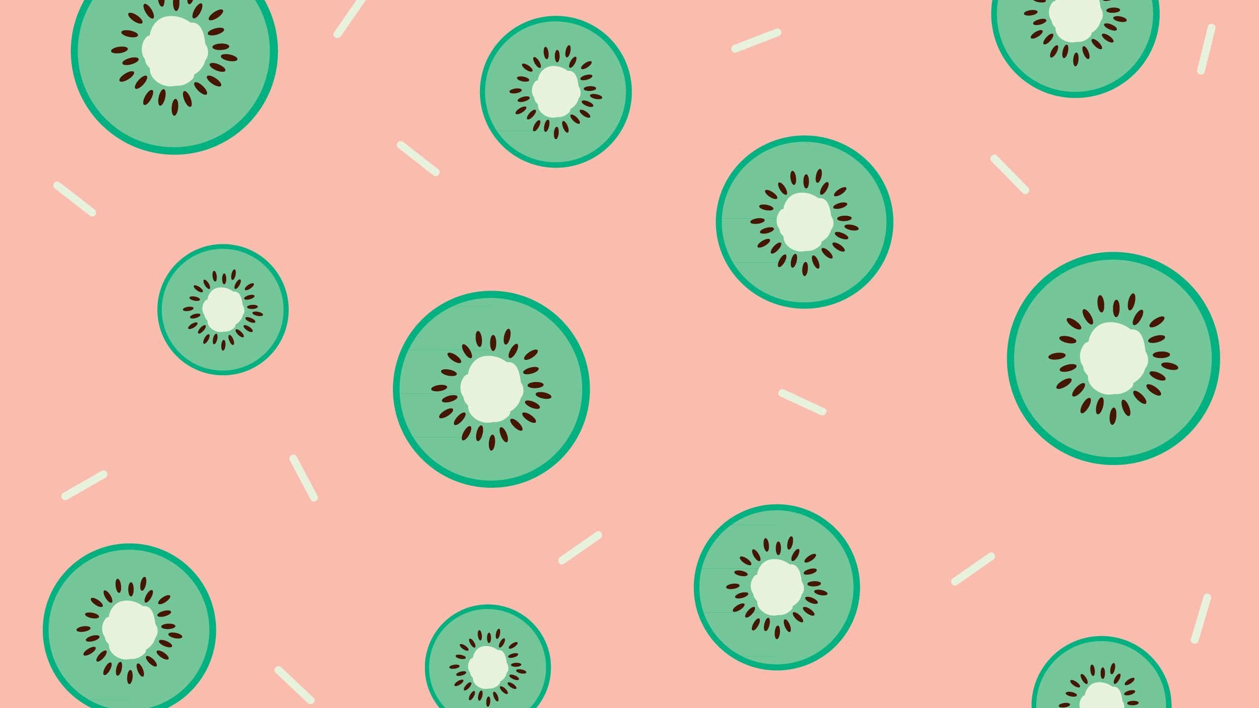 A pattern of green kiwi slices on a salmon pink background - Kiwi