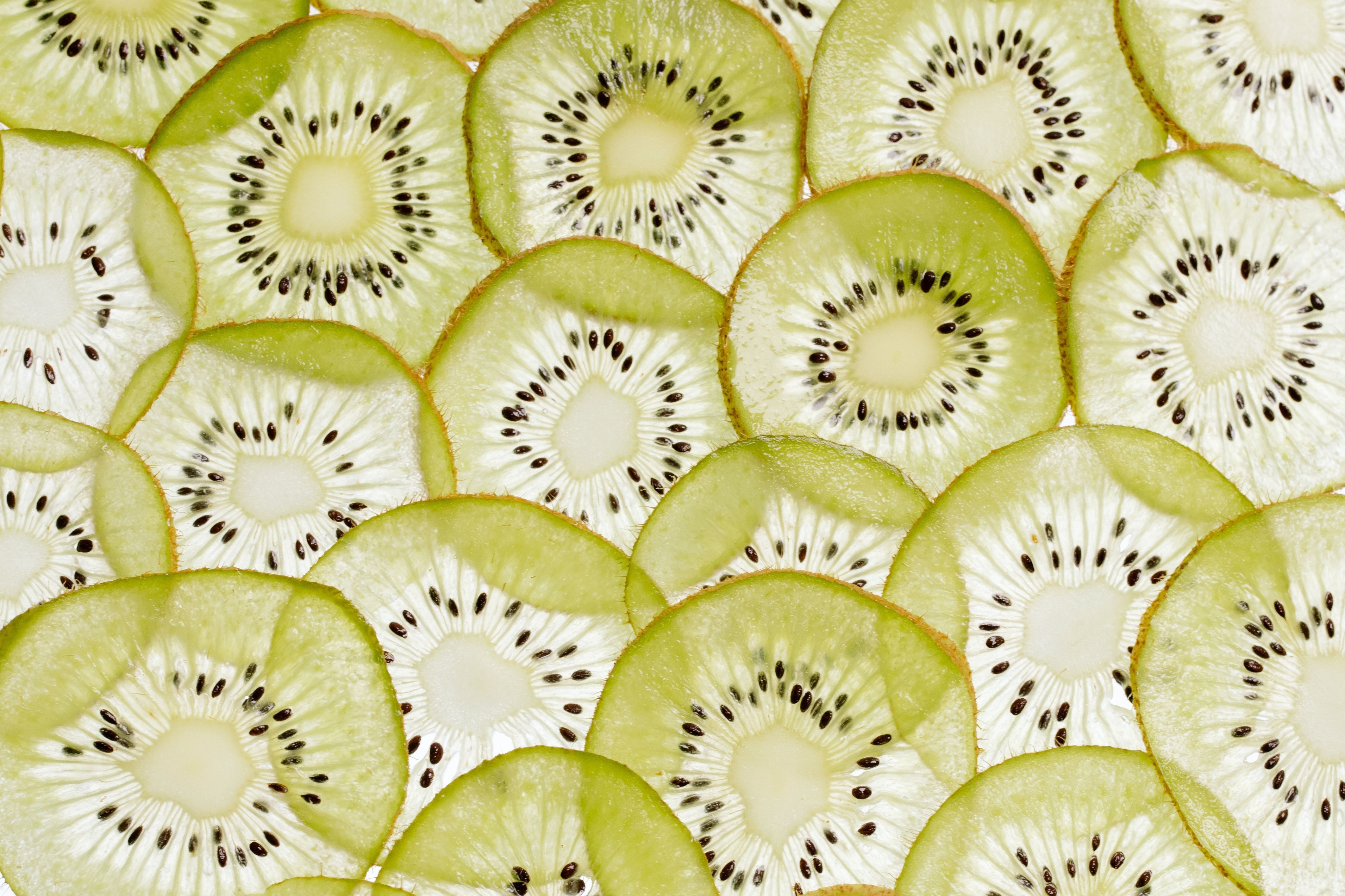 Close Up Shot Of Slices Of Kiwi On A White Surface · Free