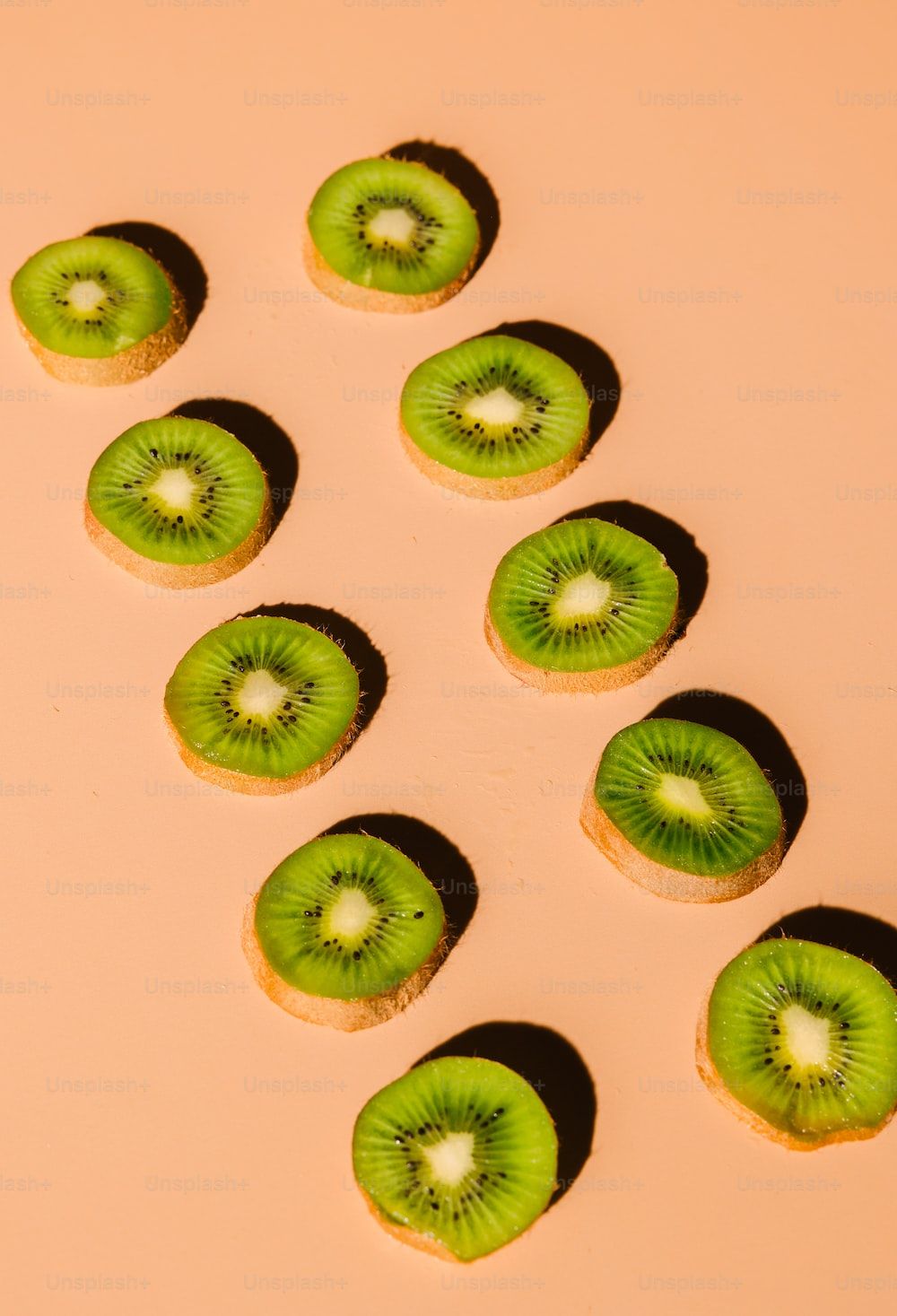 Sliced kiwi fruit on a pink background - Kiwi