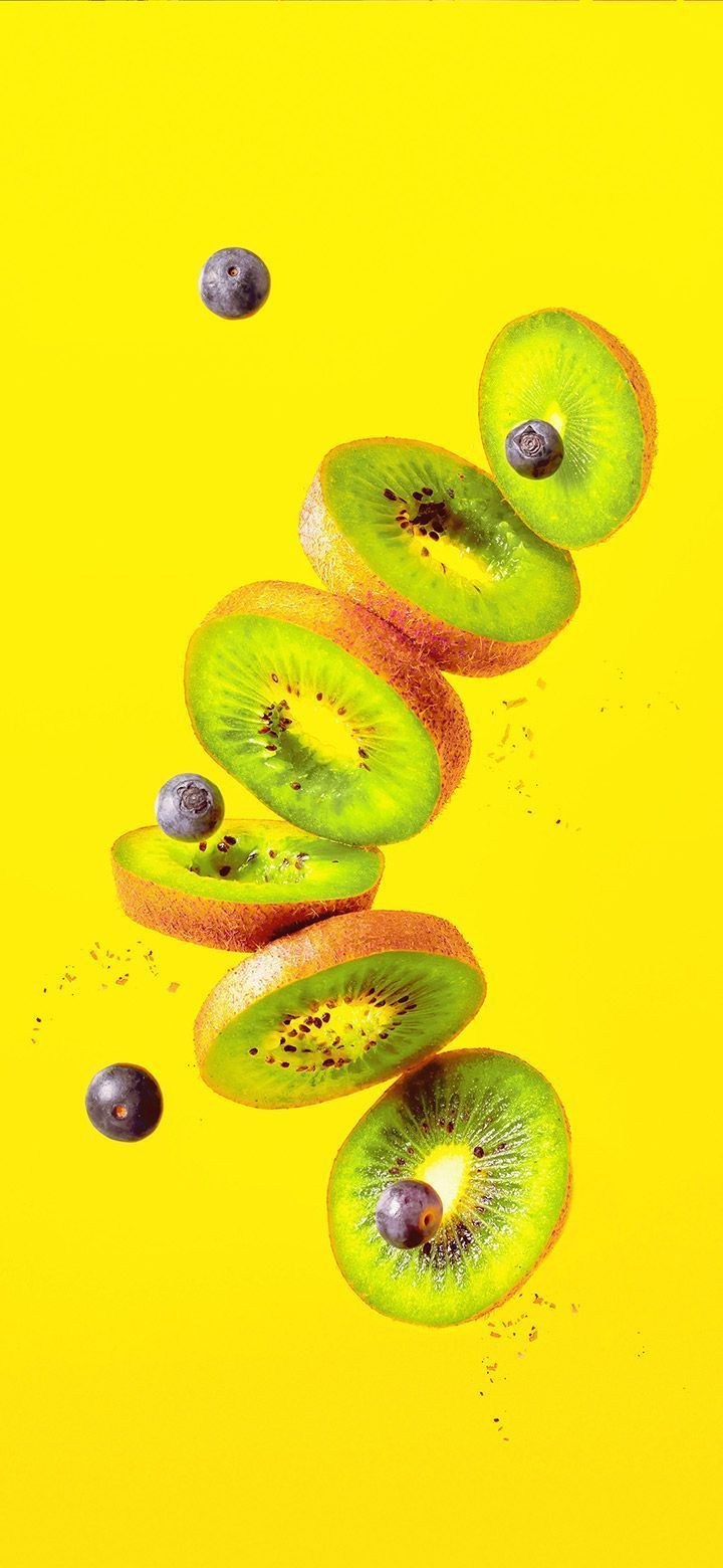 A yellow background with kiwi slices and black dots - Kiwi, fruit