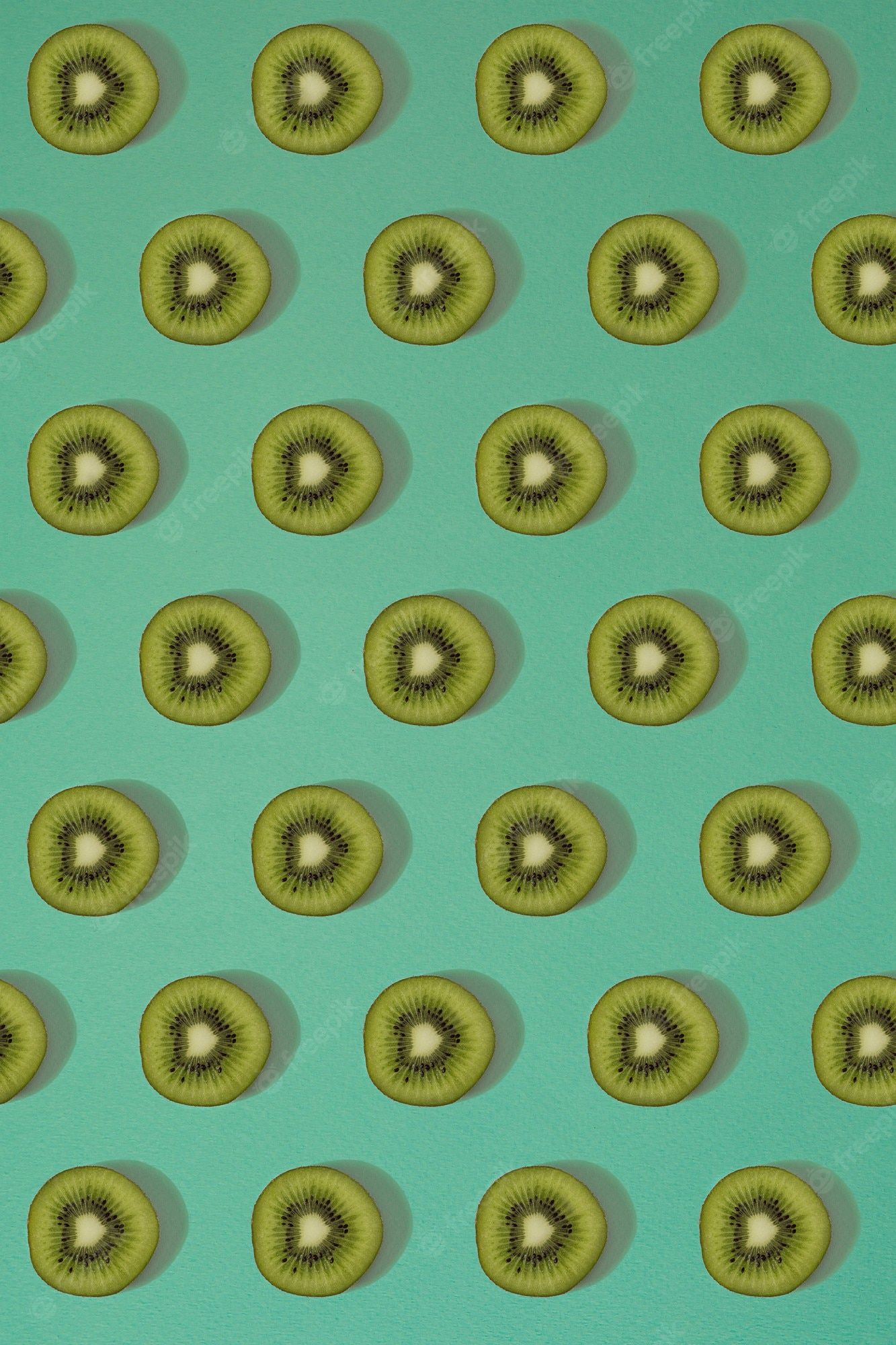 Sliced kiwi fruit arranged on a green background - Kiwi