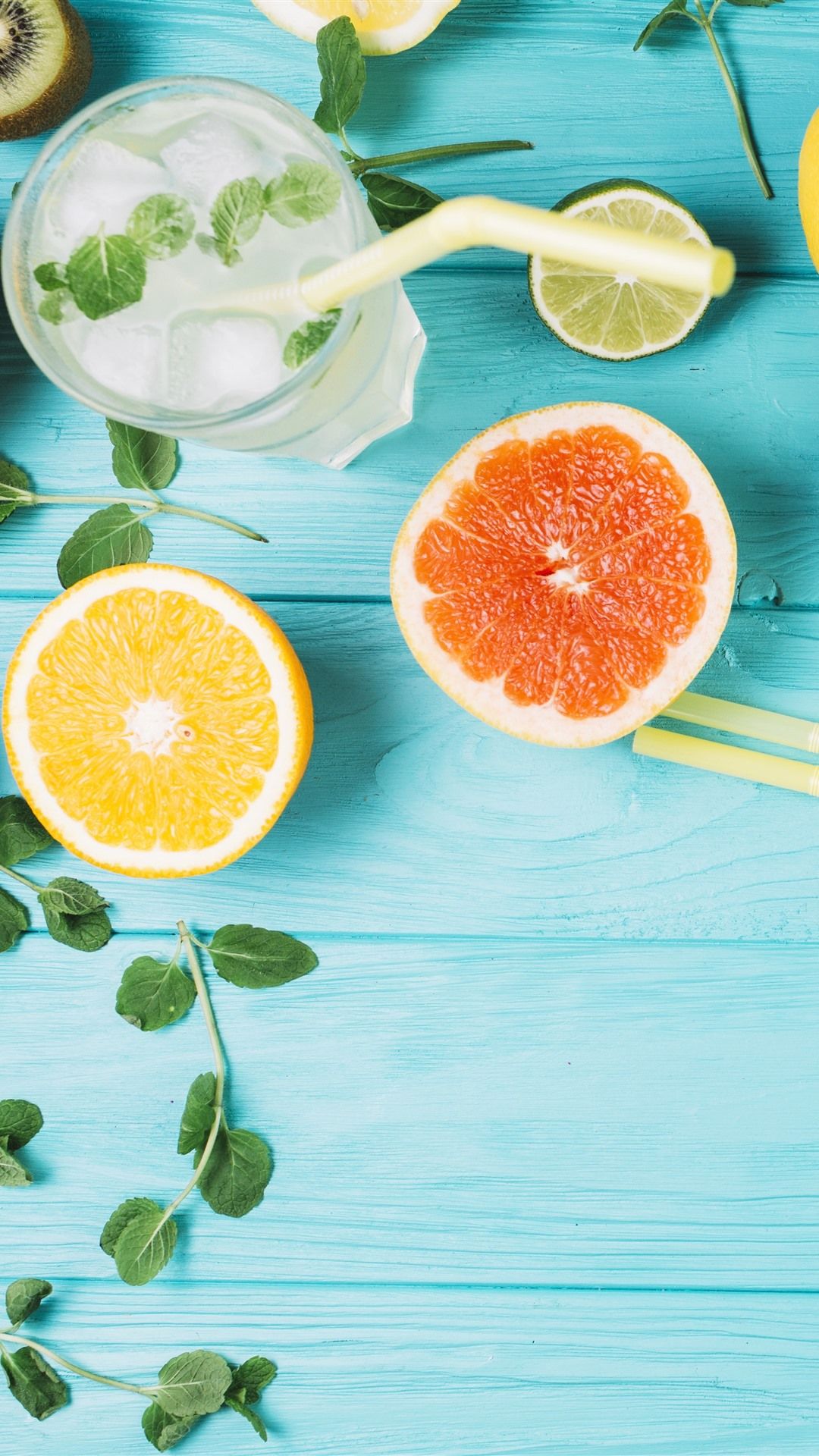 Blue wooden table with grapefruit, orange, kiwi, mint leaves and a glass of water - Kiwi