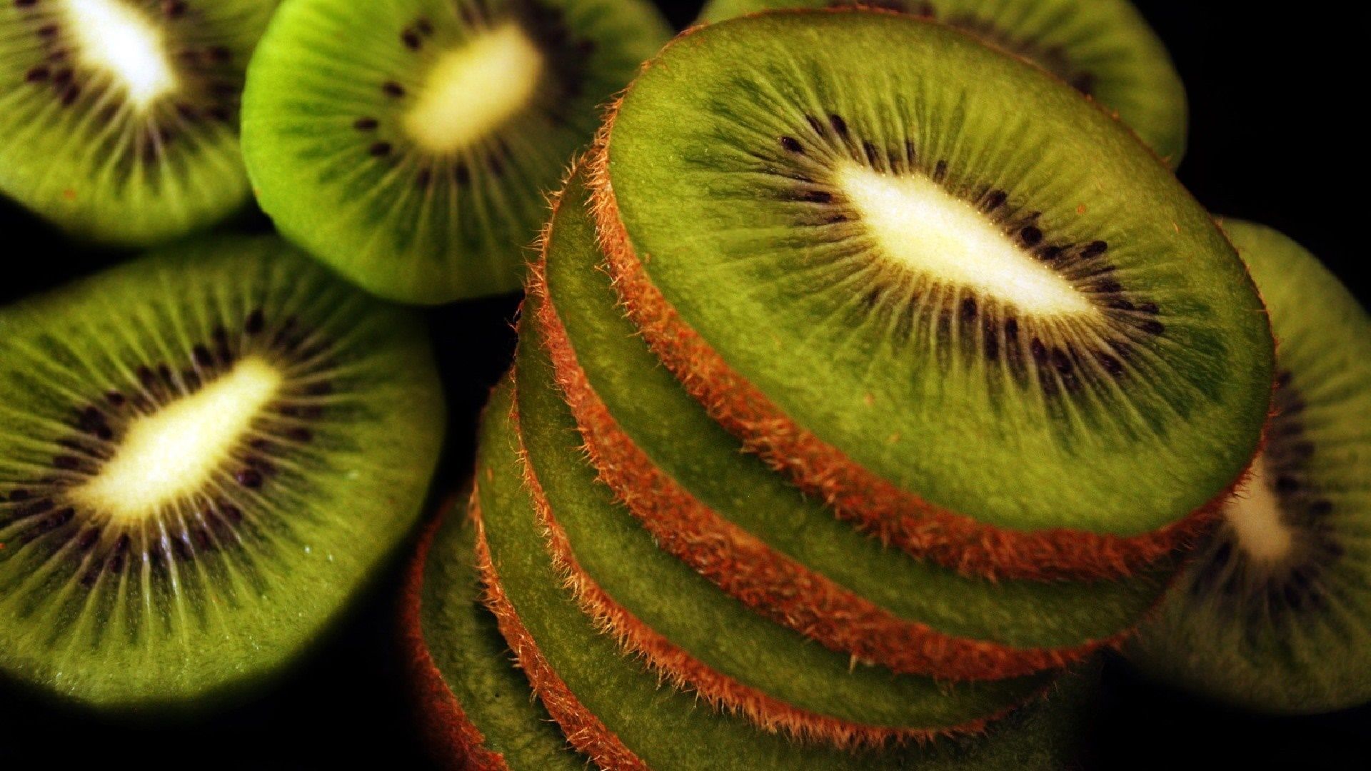 A pile of sliced kiwi fruit. - Kiwi