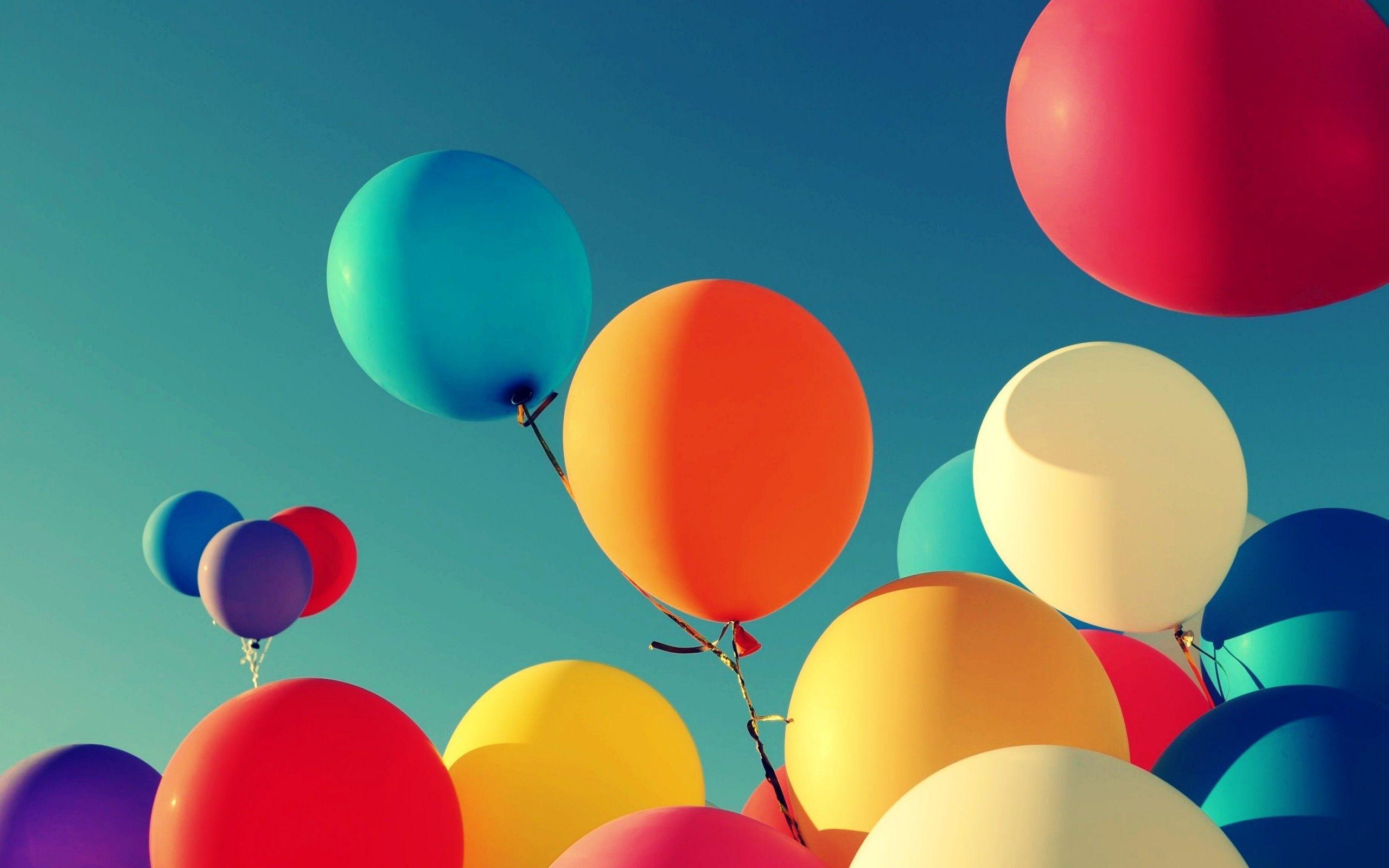 A group of colorful balloons are floating in the air - Balloons