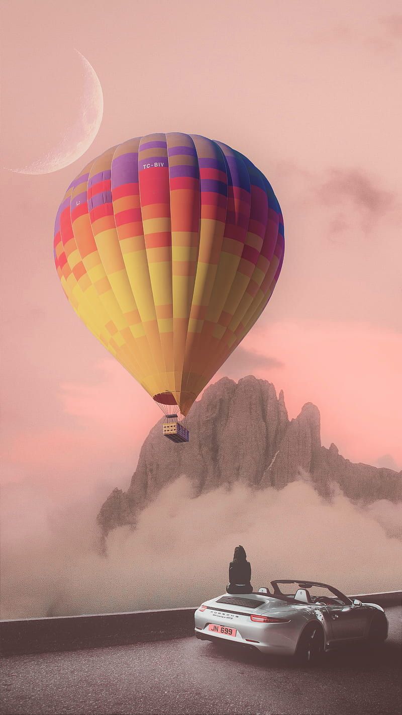 A person in a sports car watching a hot air balloon - Hot air balloons