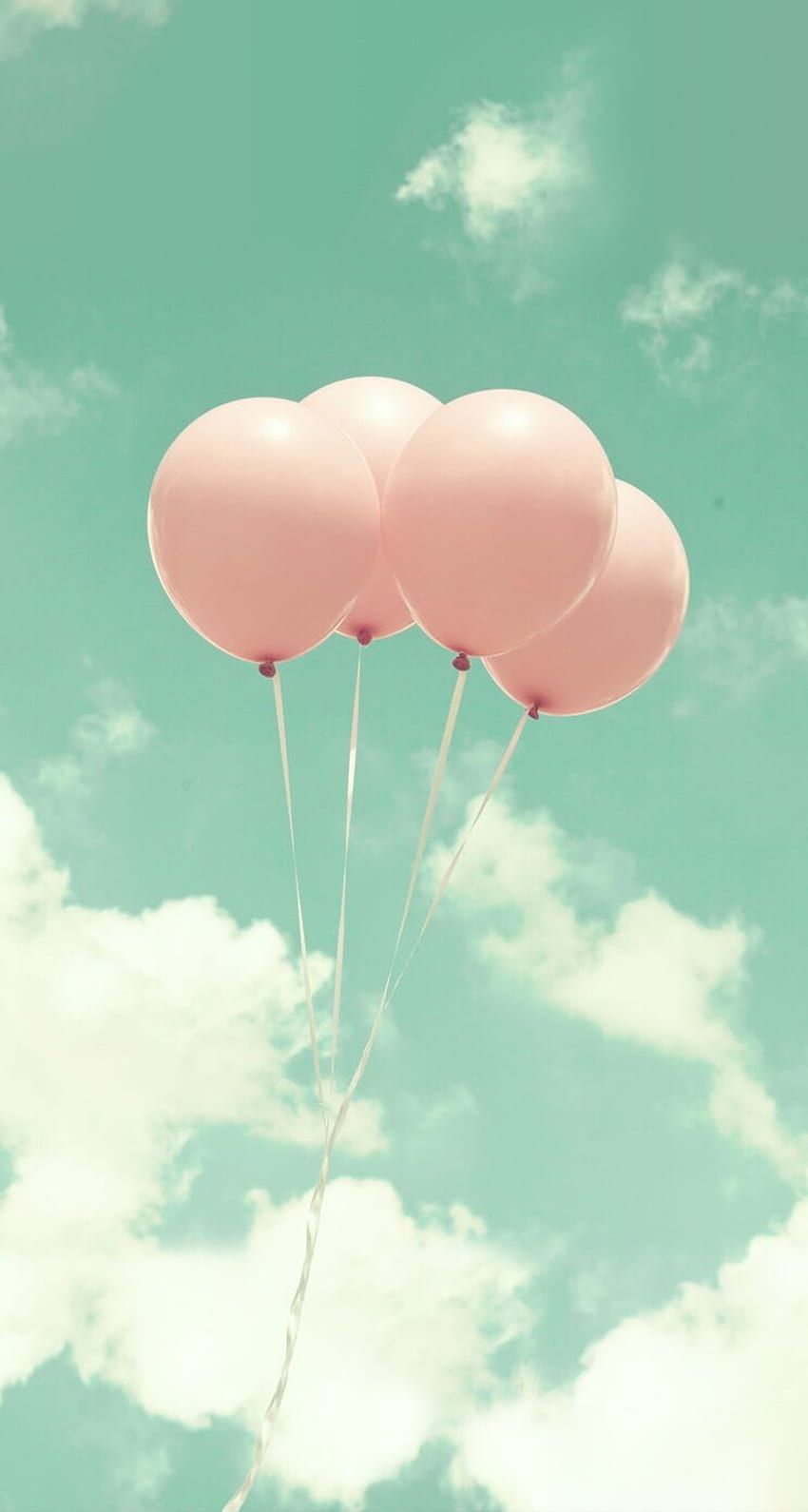 Four pink balloons floating in a blue sky - Balloons