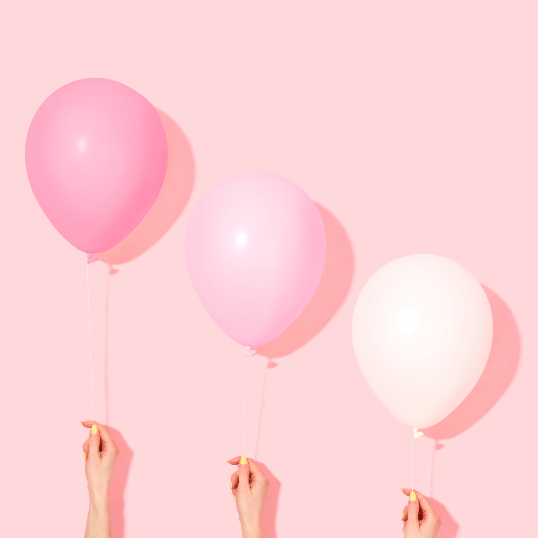 Three hands holding up pink and white balloons - Balloons, birthday