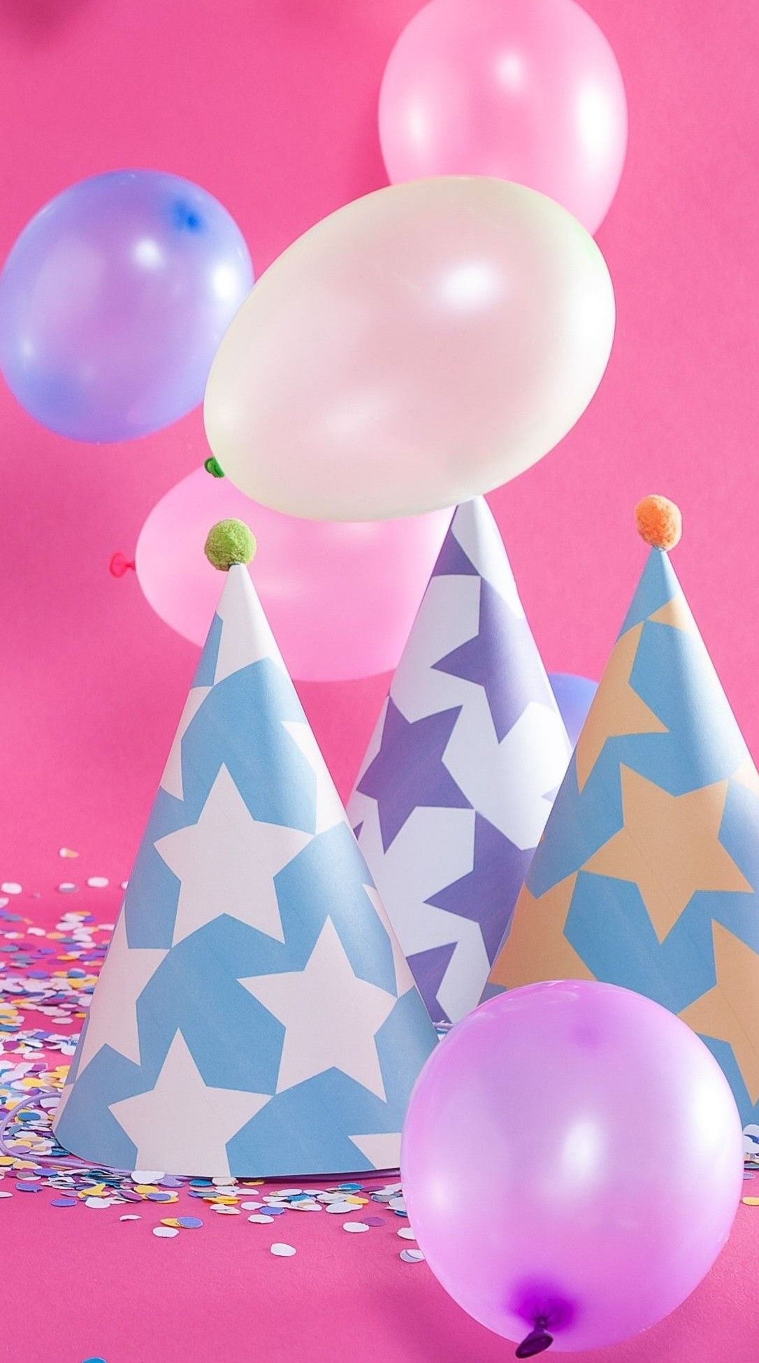 Three party hats with balloons and confetti on a pink background - Balloons, birthday