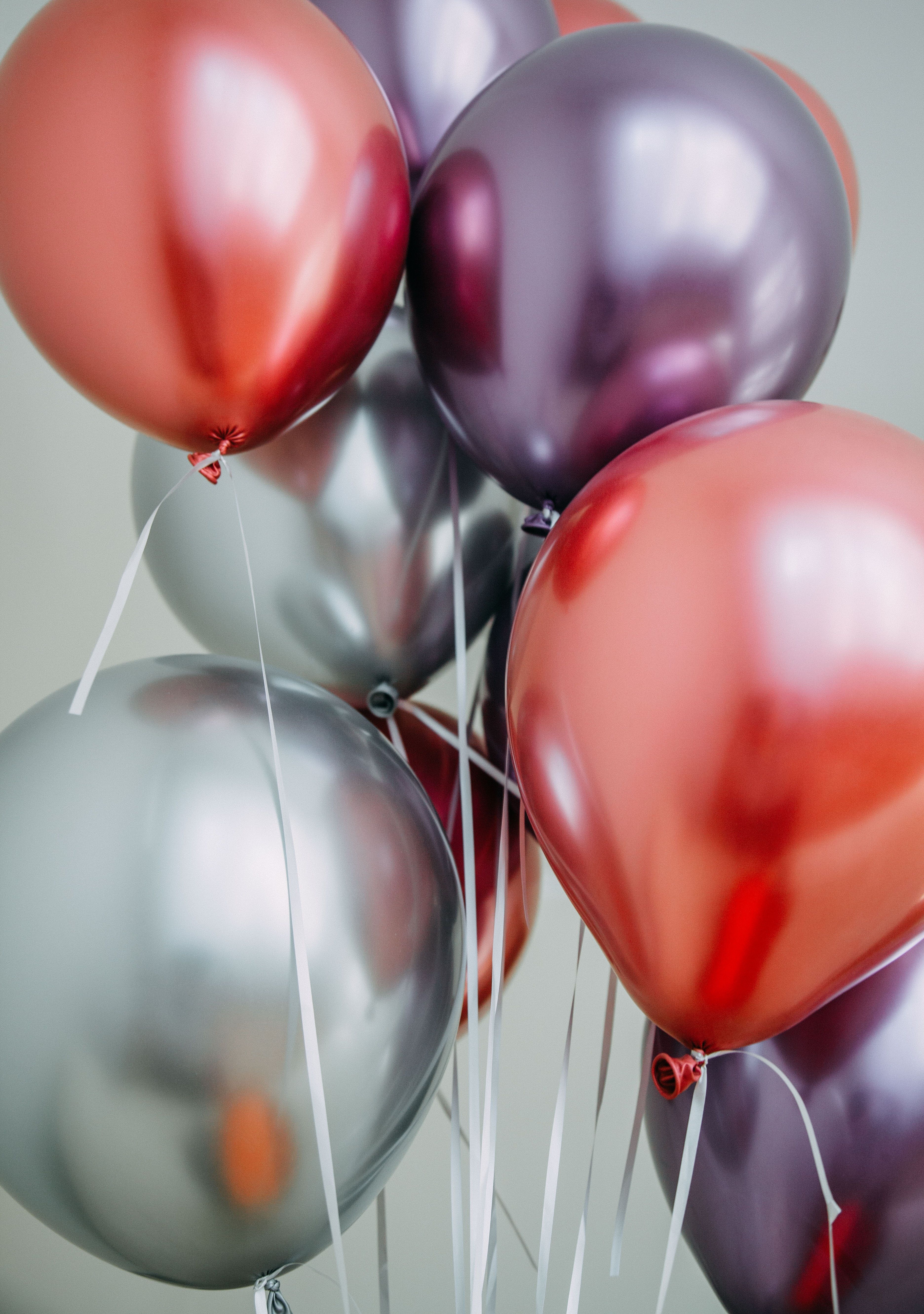 A bunch of metallic balloons in red, silver and purple. - Balloons