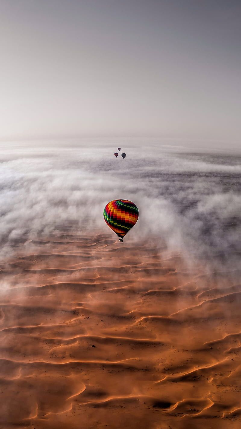A group of hot air balloons flying over the desert - Hot air balloons