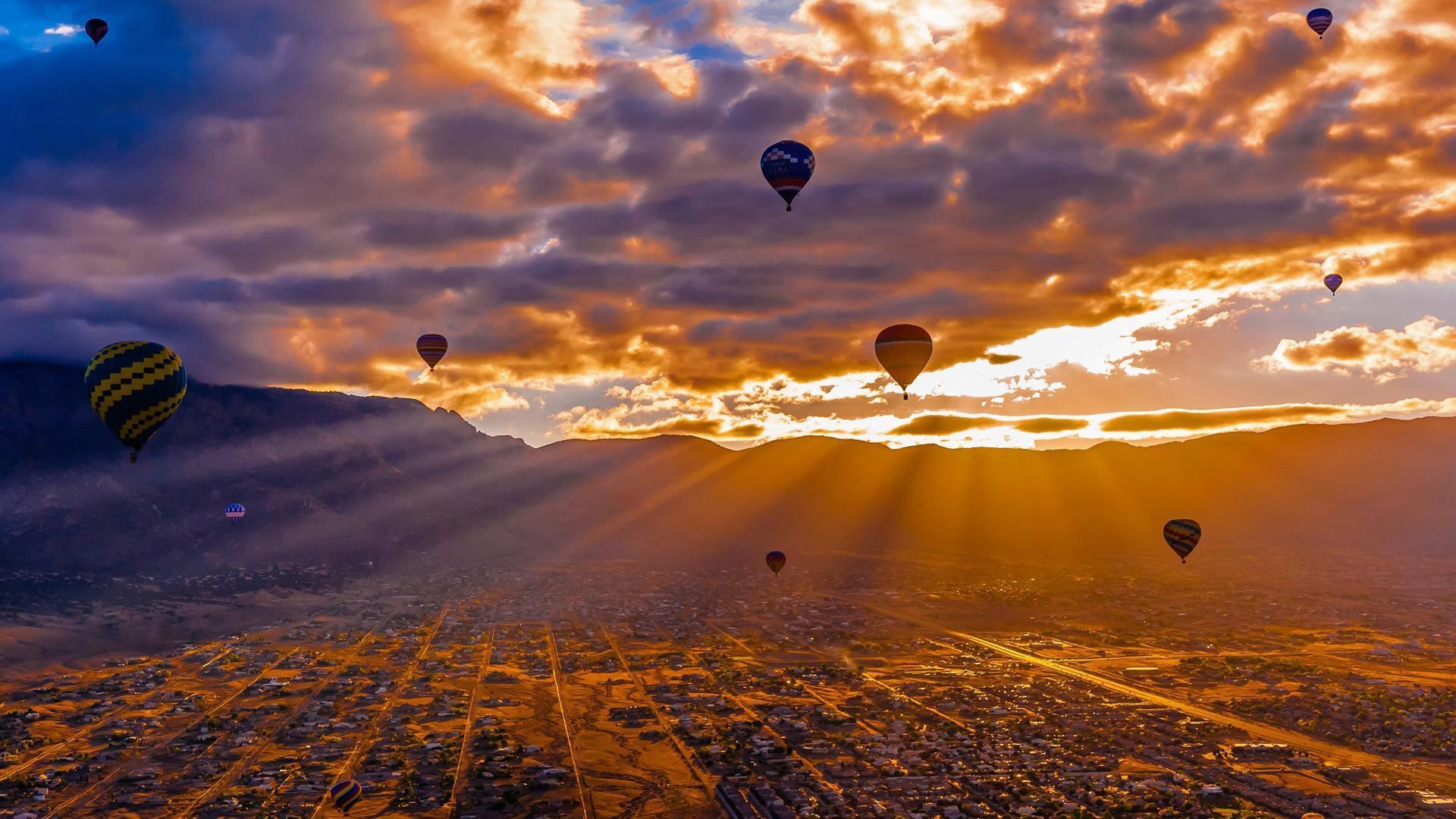 A group of hot air balloons flying over mountains - Hot air balloons