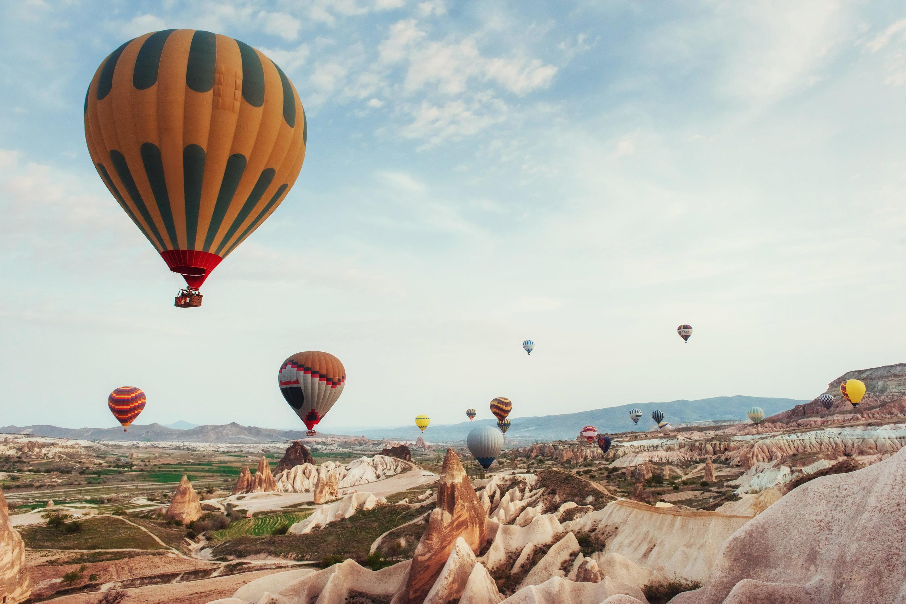 Hot air balloon flying over rock landscape at Cappadocia Turkey