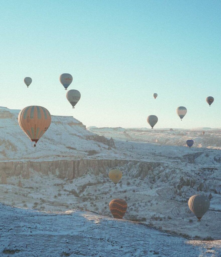 Hot air balloons floating over a snowy mountain - Hot air balloons