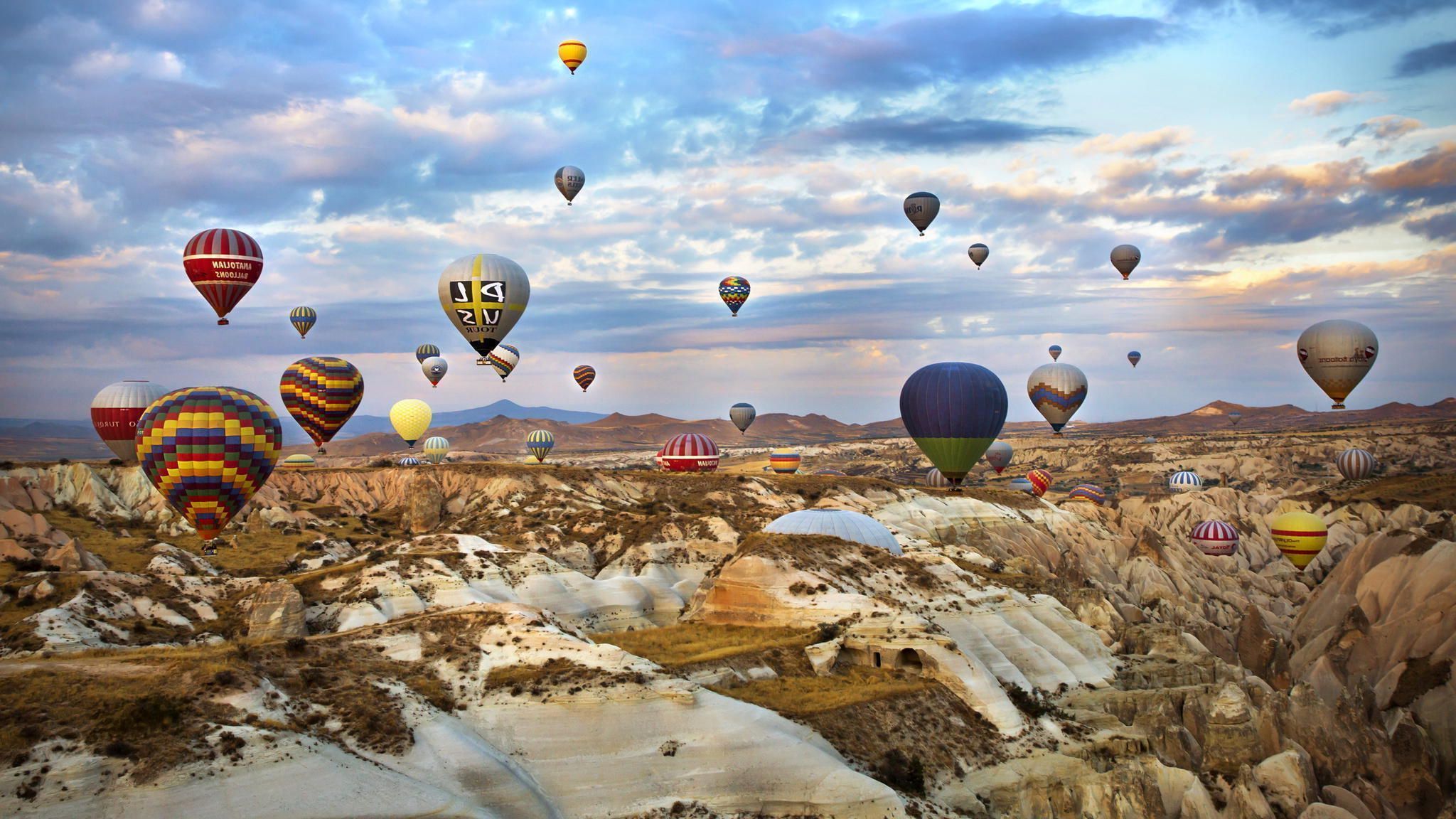 Hot air balloons flying over a rocky landscape - Hot air balloons