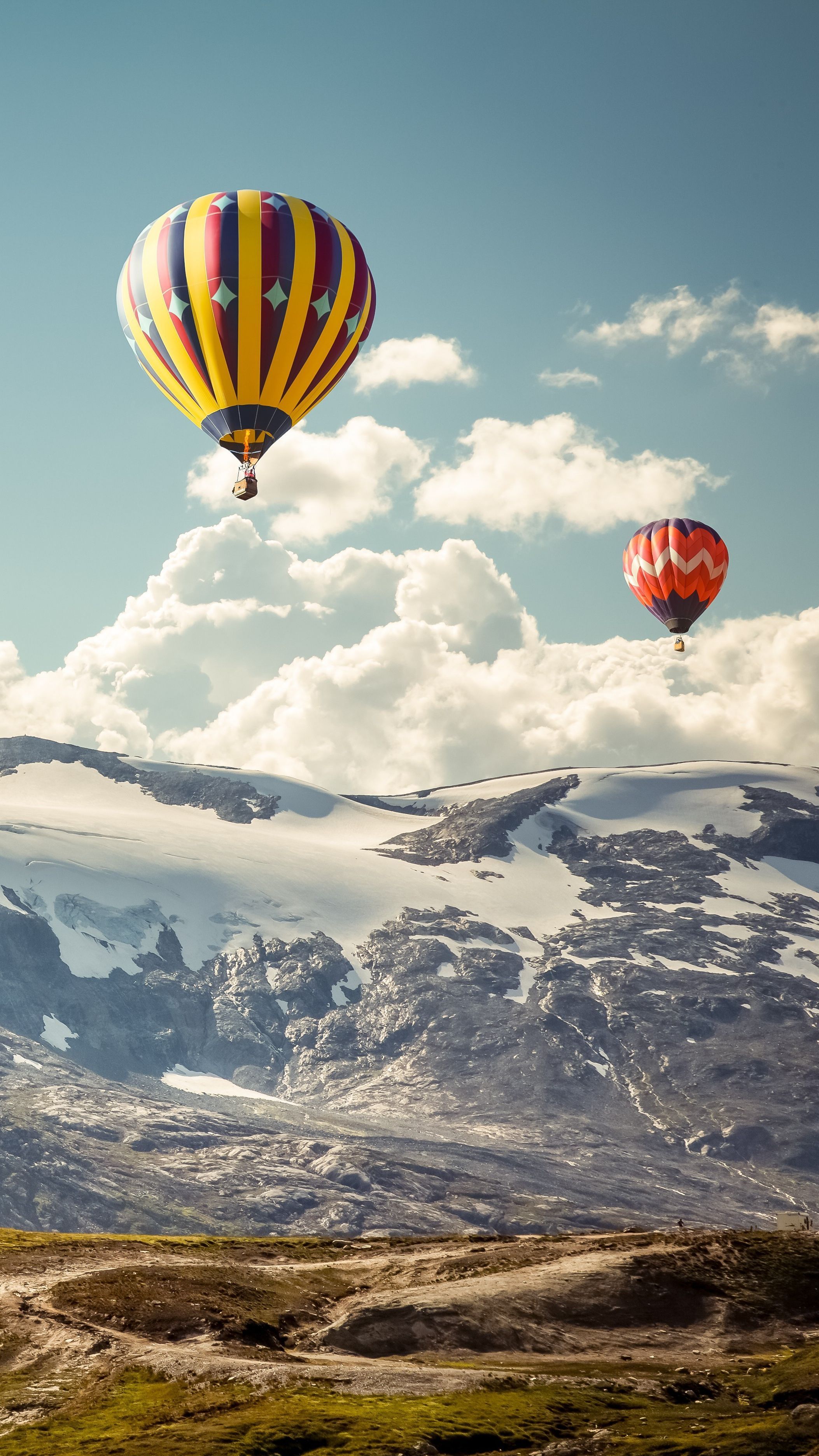 A group of hot air balloons flying over the mountains - Hot air balloons