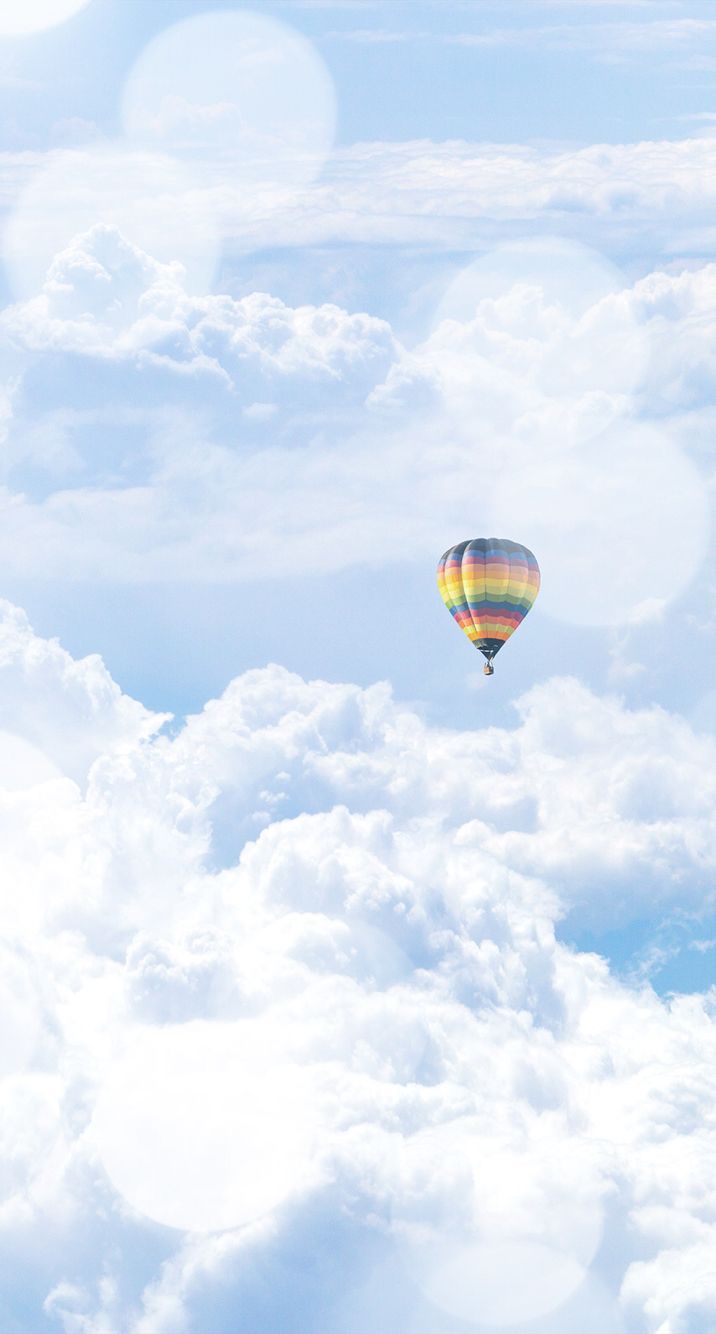 A hot air balloon flying through the clouds - Hot air balloons