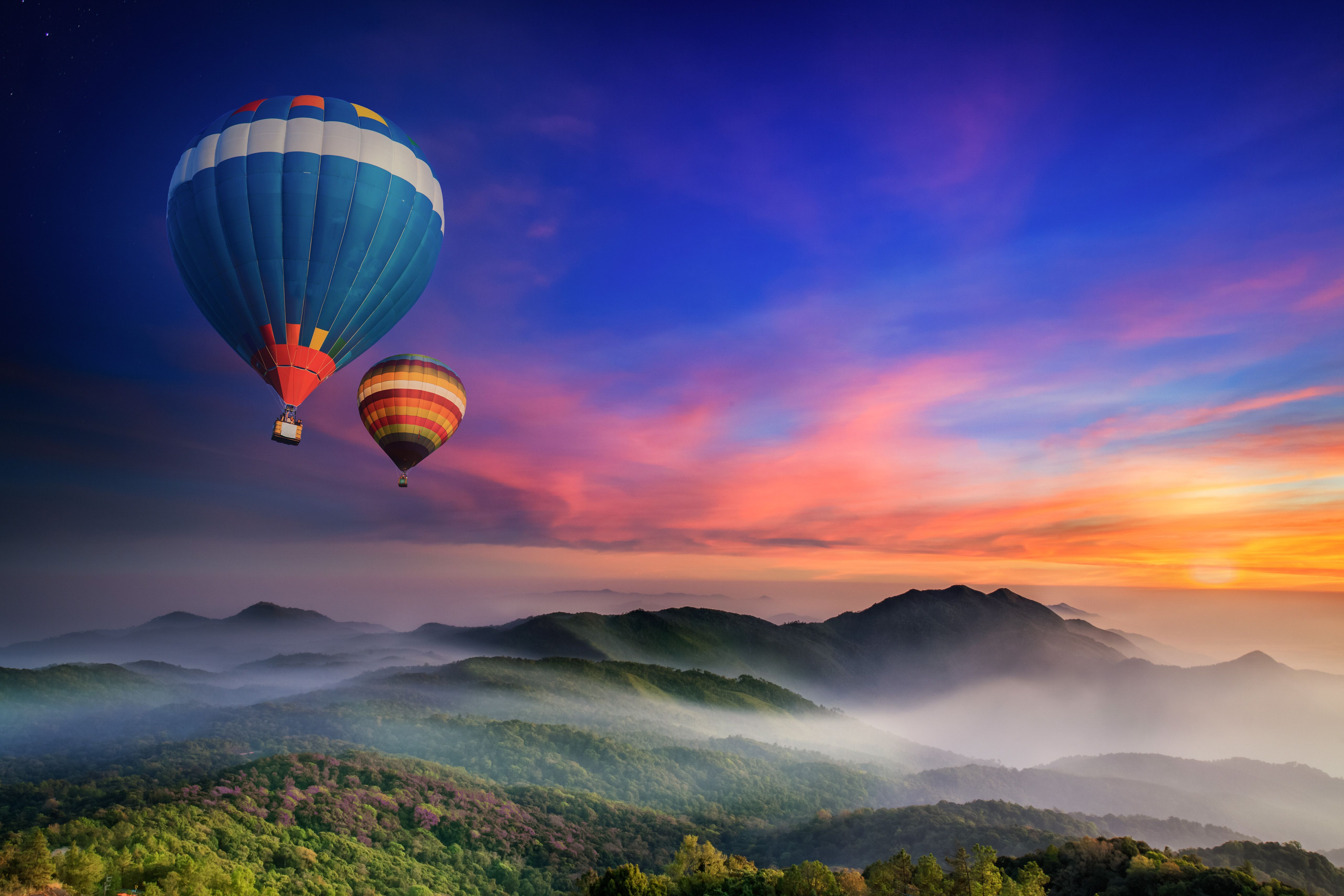 Hot air balloons flying over a mountain - Hot air balloons