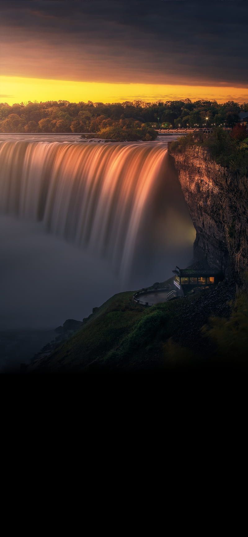 A waterfall is flowing over the edge of cliff - Waterfall