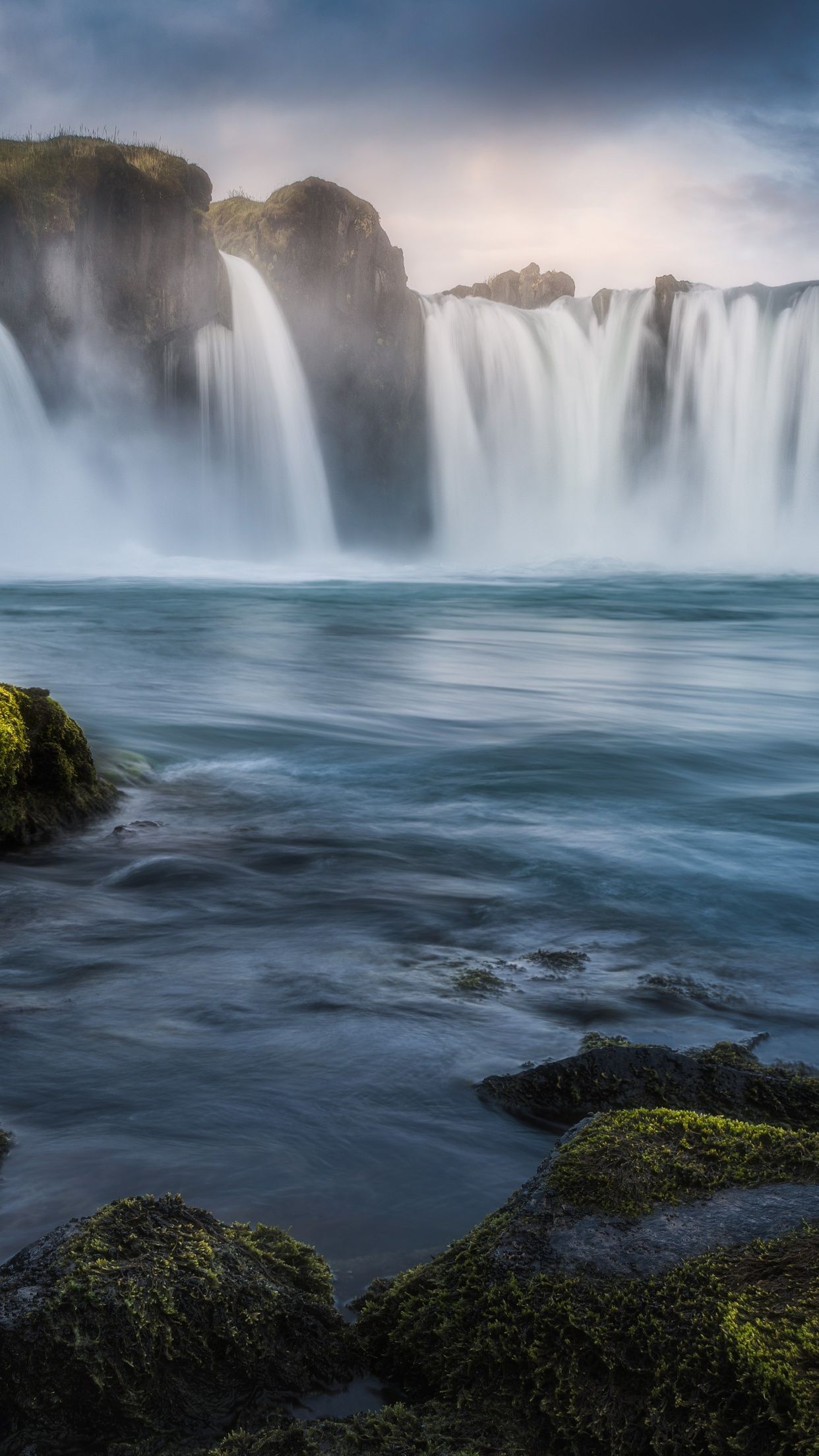 Godafoss waterfall in Iceland during sunrise with mossy rocks in the foreground - Waterfall