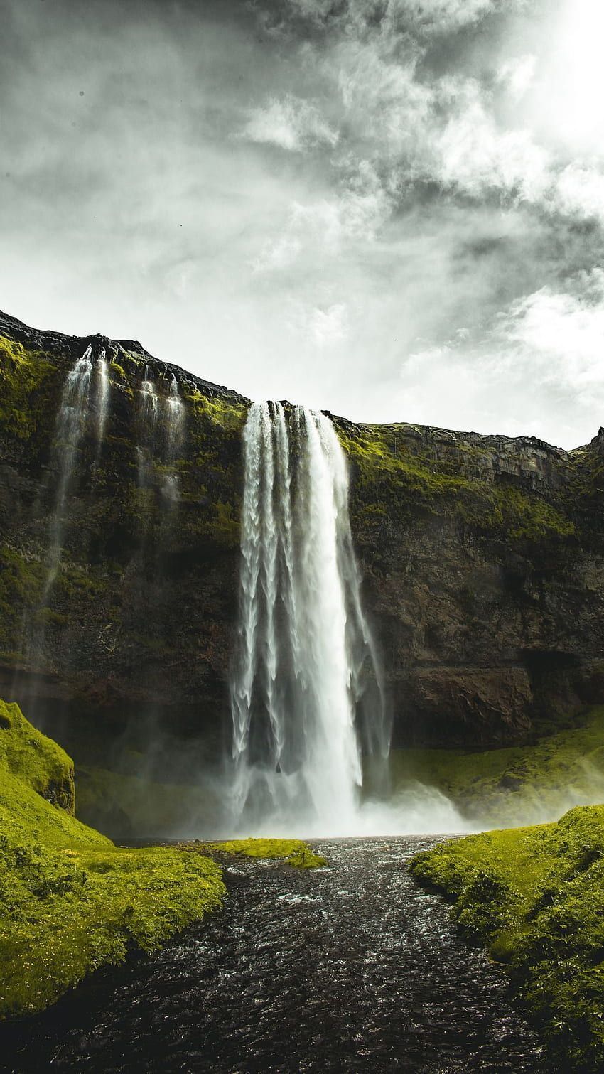 A waterfall in the middle of a green field - Waterfall