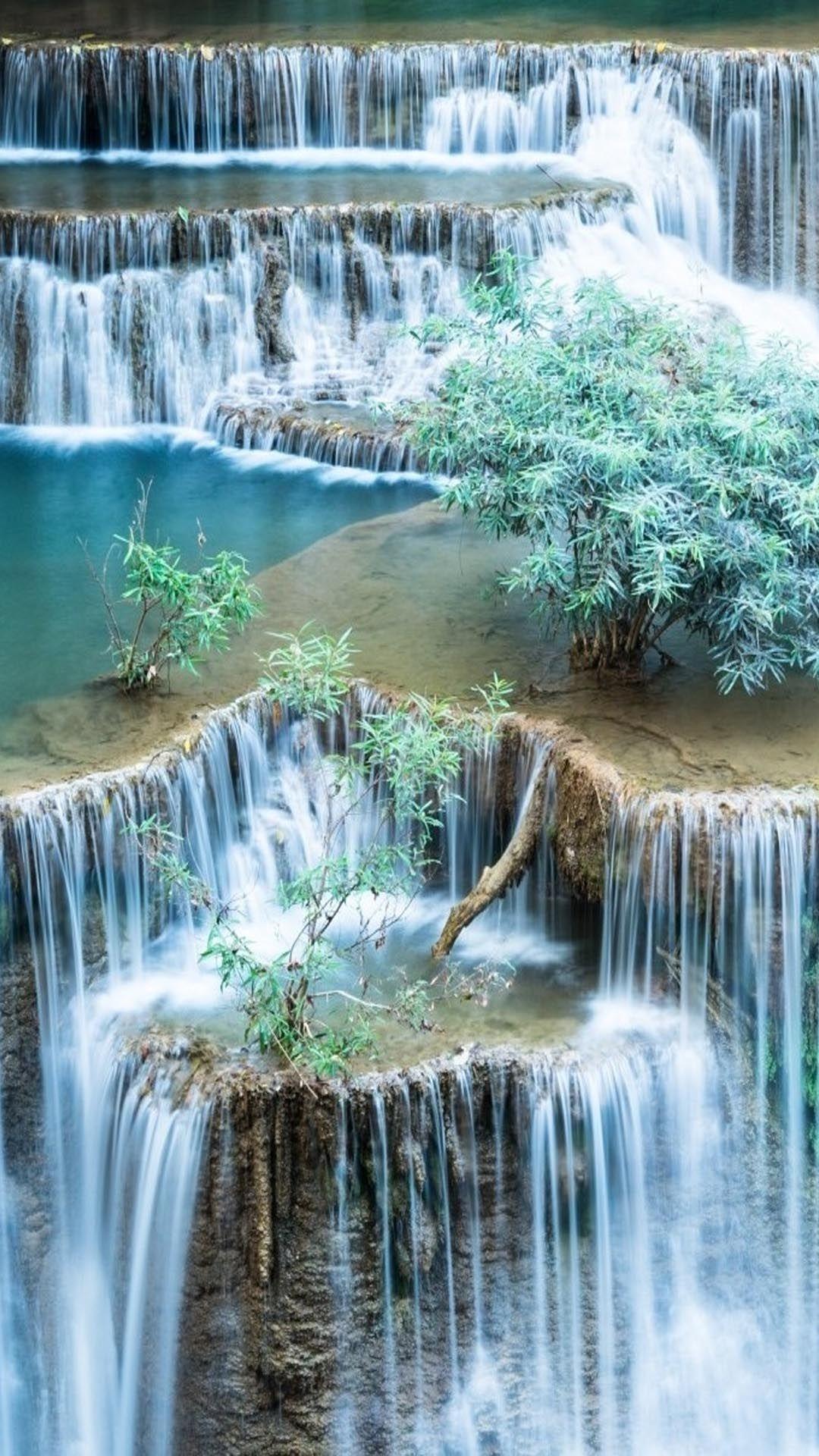 A waterfall with many tiers and trees growing on the rocks - Waterfall