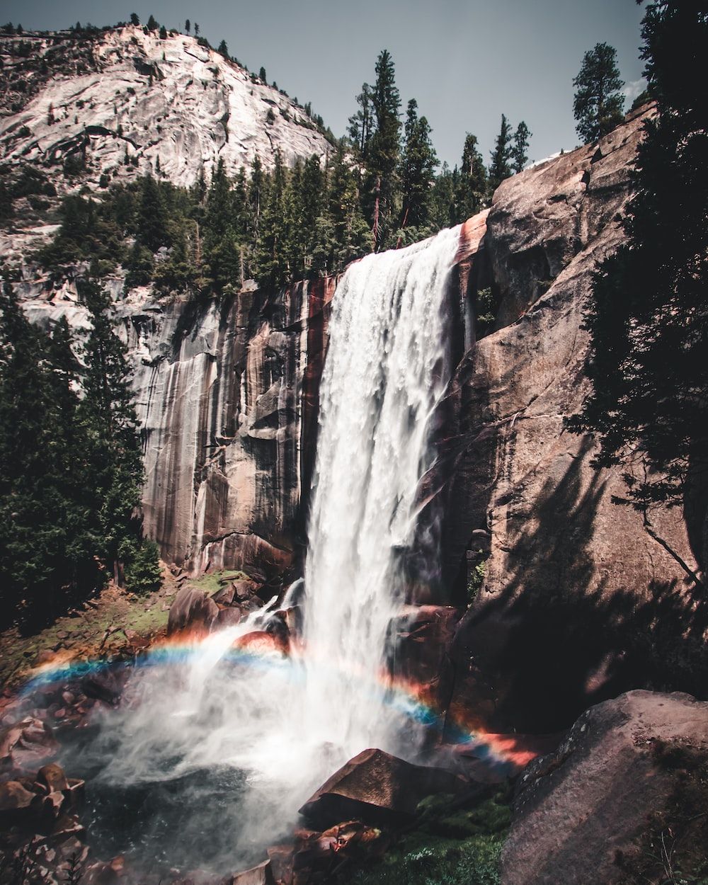 A rainbow is seen in the sky - Waterfall