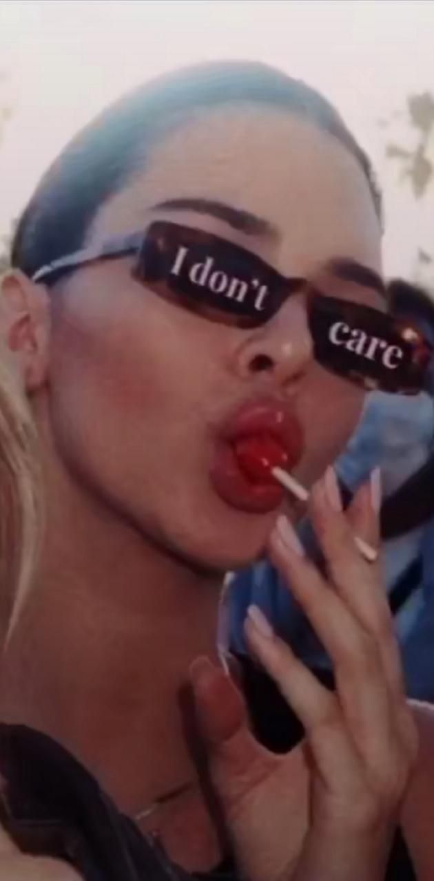 A woman wearing sunglasses licking a lollypop - Lips