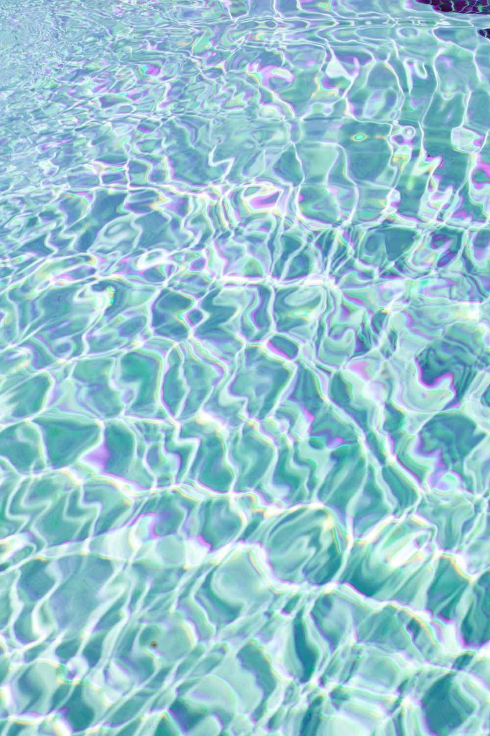 a pool with clear blue water and a rock in the middle photo