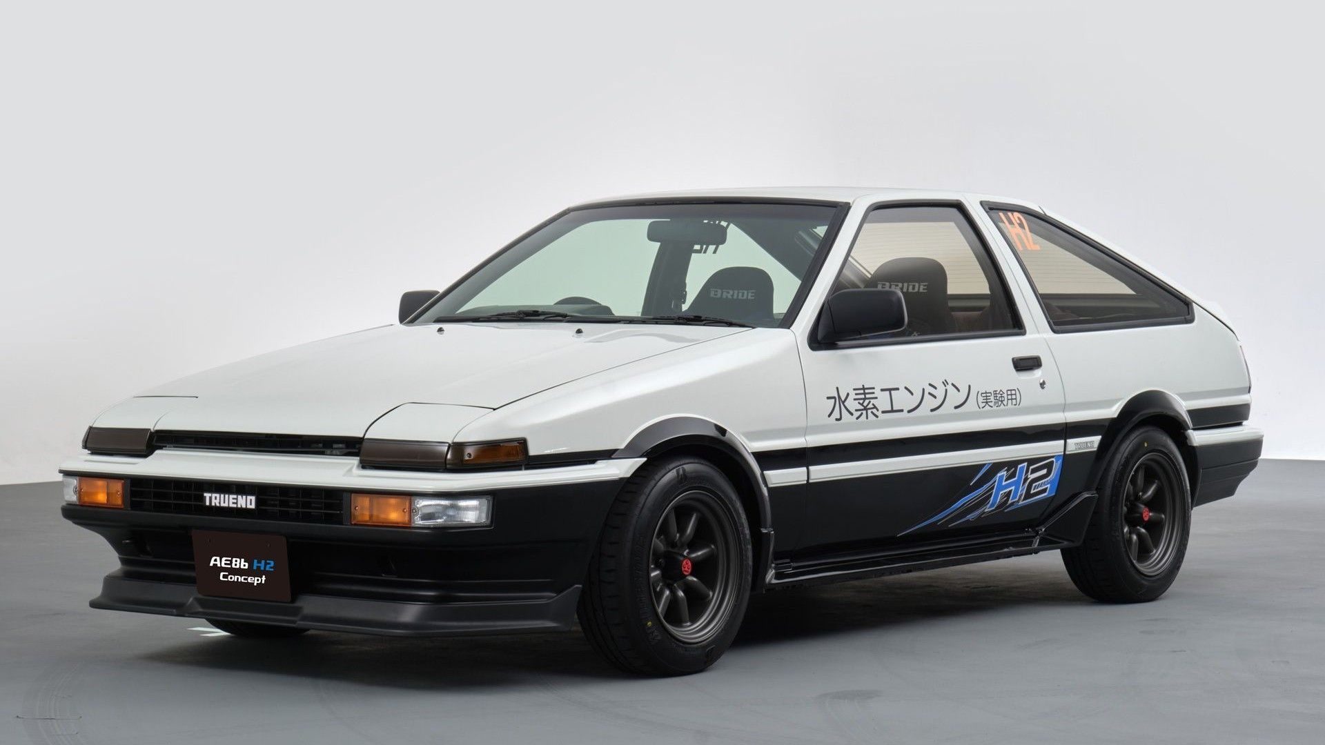 A white 1980s Toyota Sprinter Trueno from the Initial D anime is parked in a white room. - Toyota AE86