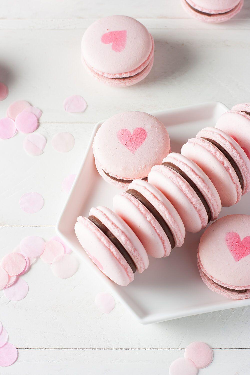 A plate of pink macaroons with hearts on them - Macarons