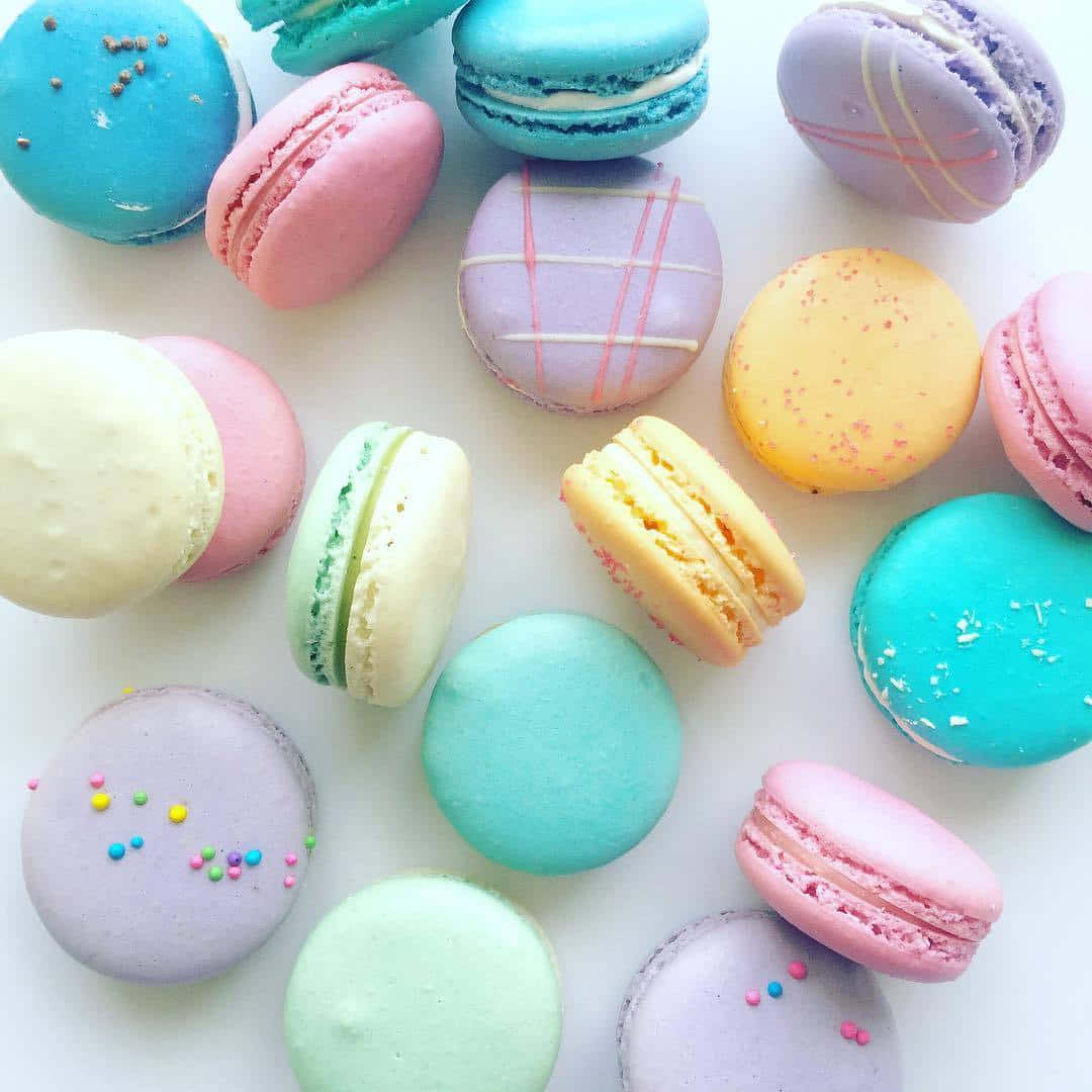 A variety of colorful macarons with sprinkles on a white background - Macarons