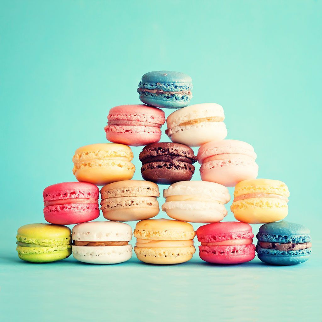 A pyramid of colorful macaroons on blue background - Macarons