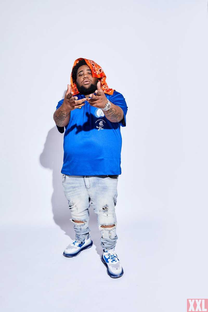 Tee Grizzley is wearing a blue shirt and a red bandana. - Rod Wave