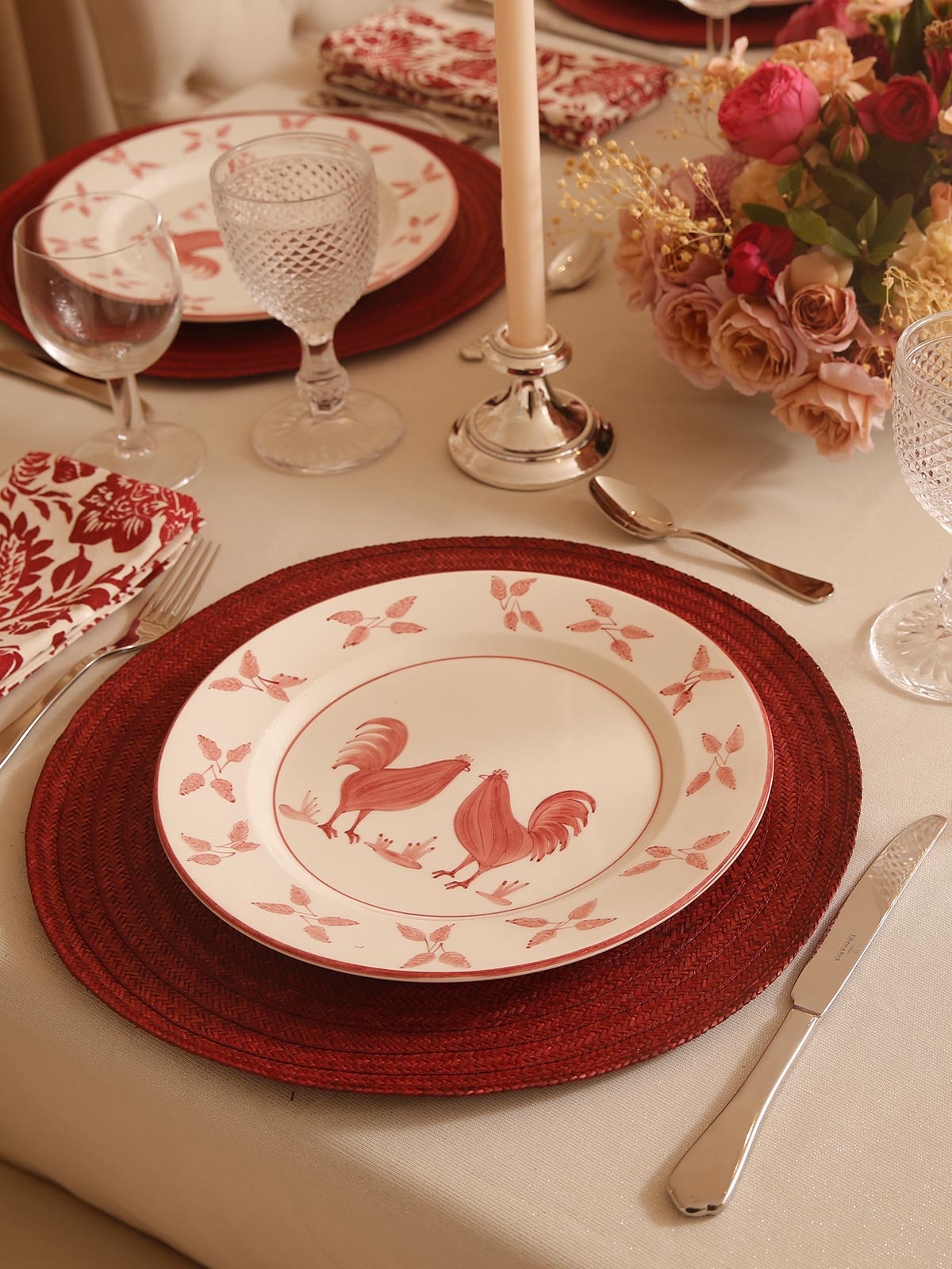 Table setting with a plate with two red roosters on it - Coquette