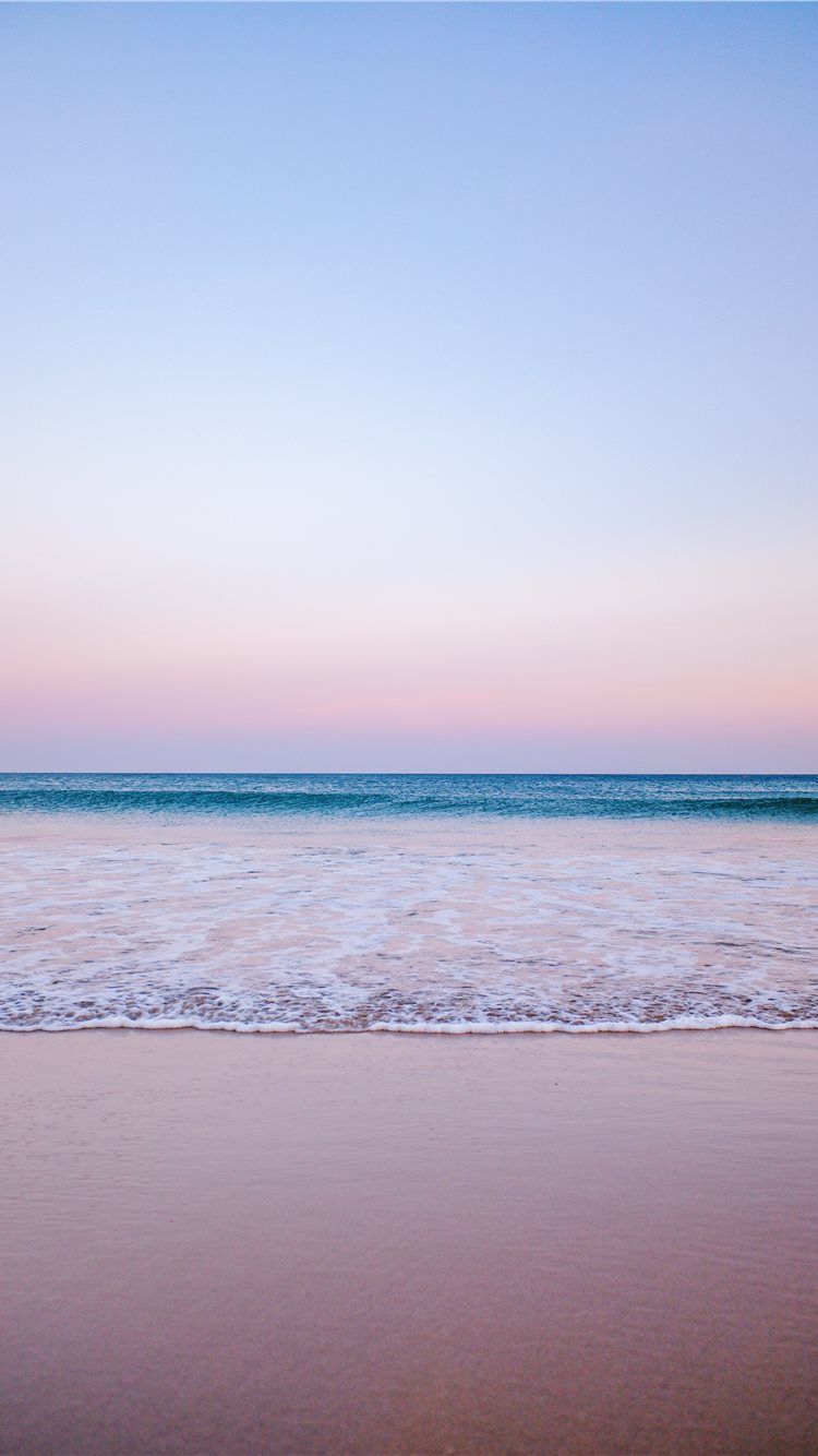 A photo of a beach at sunset with the waves gently rolling in - Coast