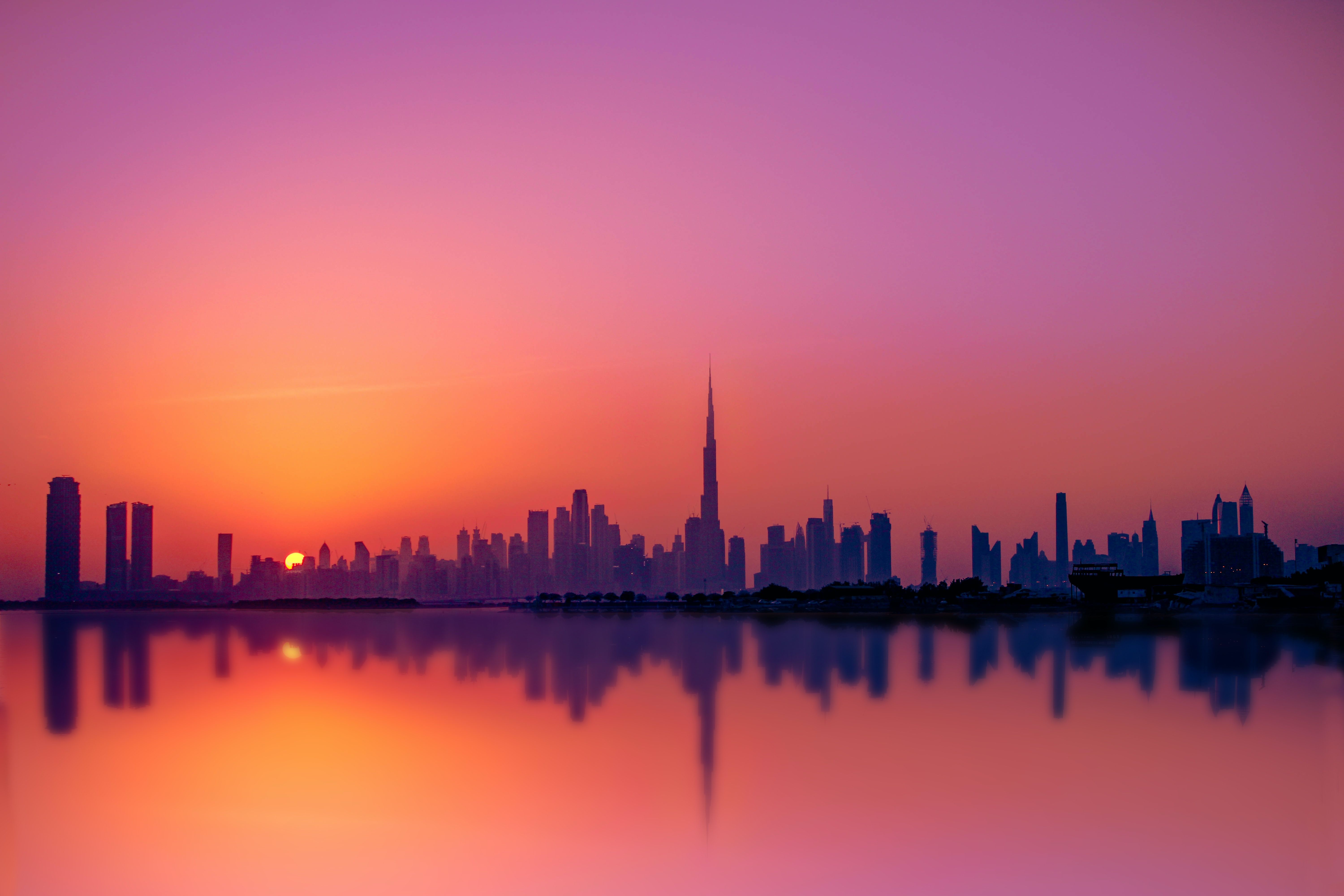 The skyline of Dubai at sunset with the Burj Khalifa in the background. - Dubai, sunset, skyline
