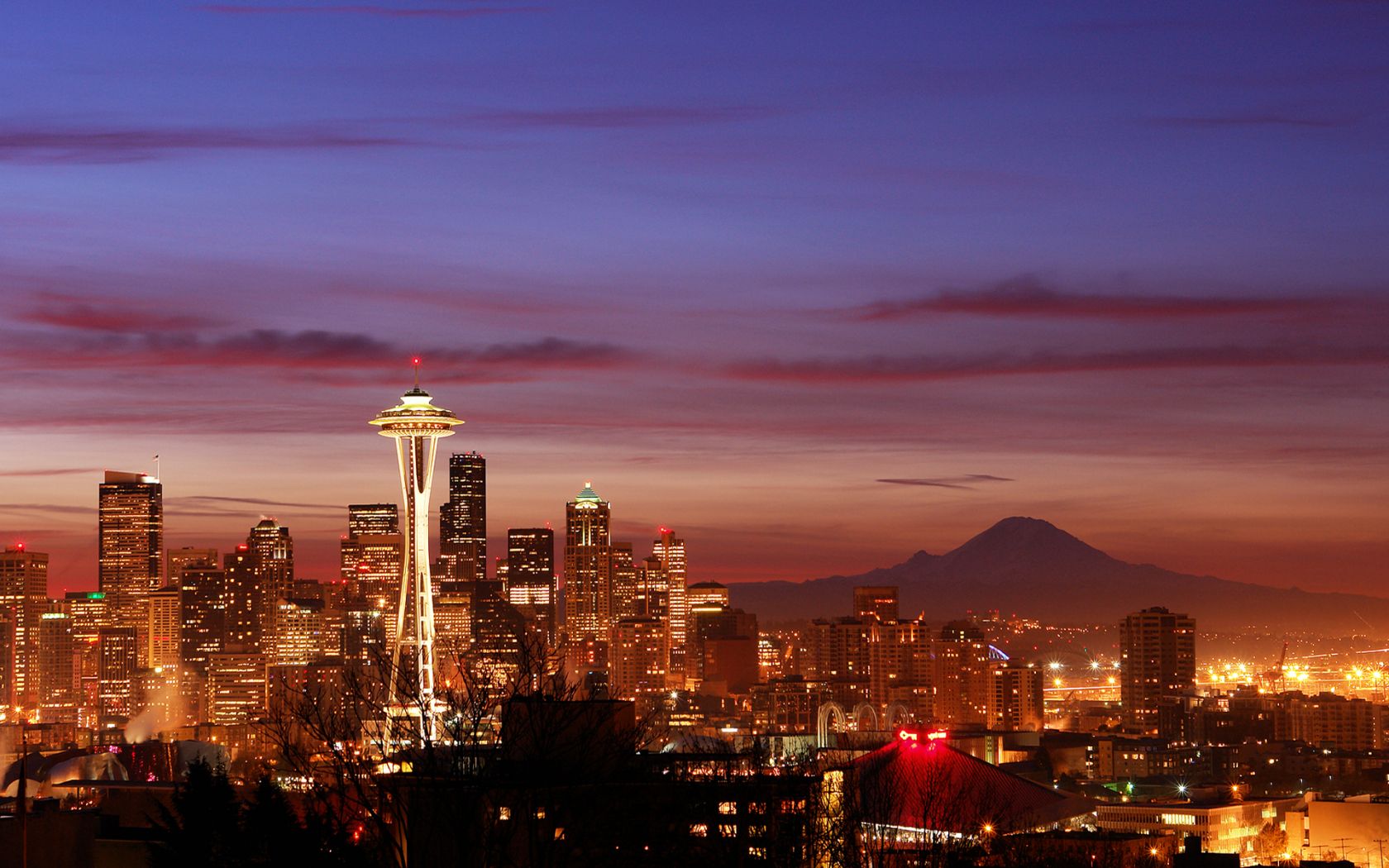 The Seattle skyline at night with the Space Needle and Mount Rainier in the background. - Skyline
