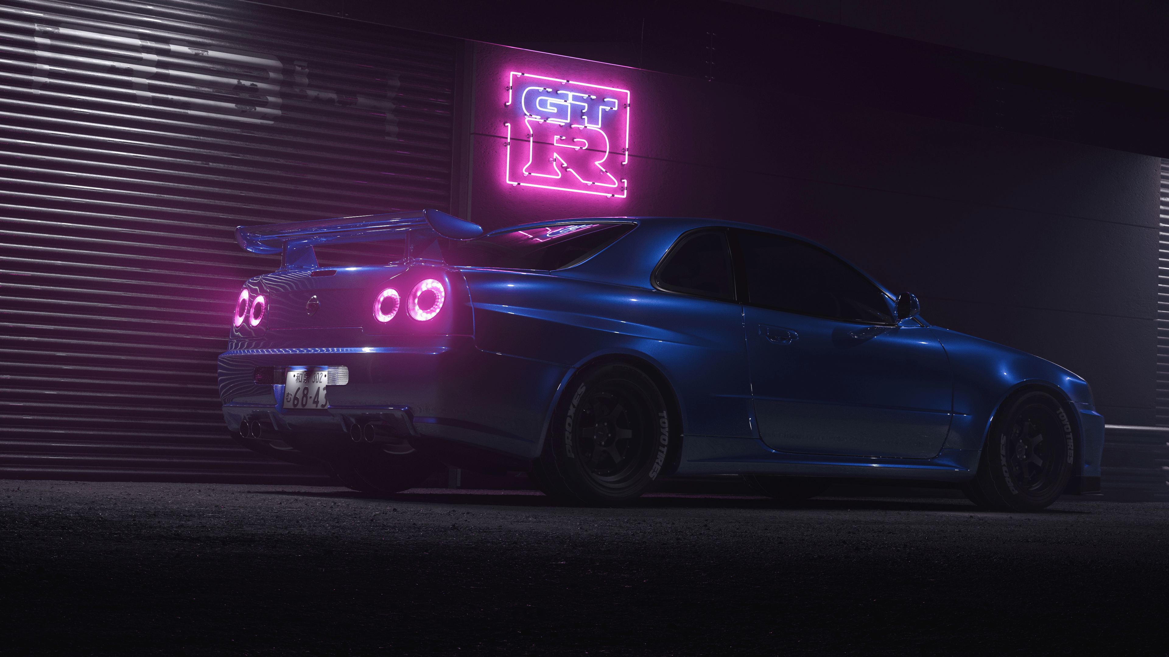 A blue car with a neon sign in the background - Nissan Skyline