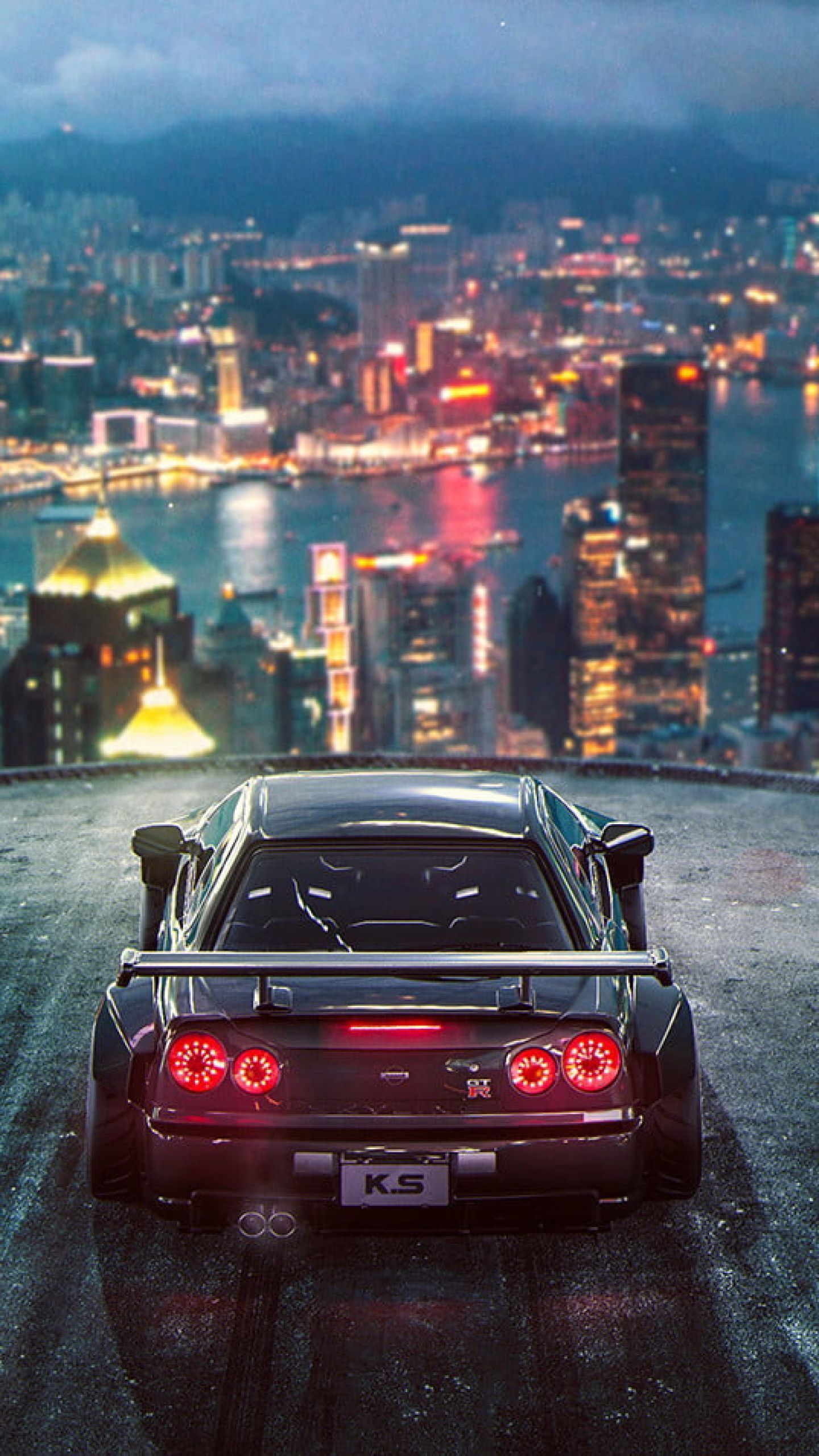 A skyline city view with a sports car in the foreground - Nissan Skyline