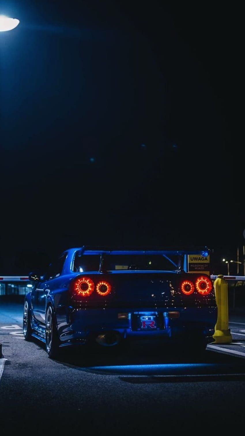 A blue sports car parked in the dark - Nissan Skyline