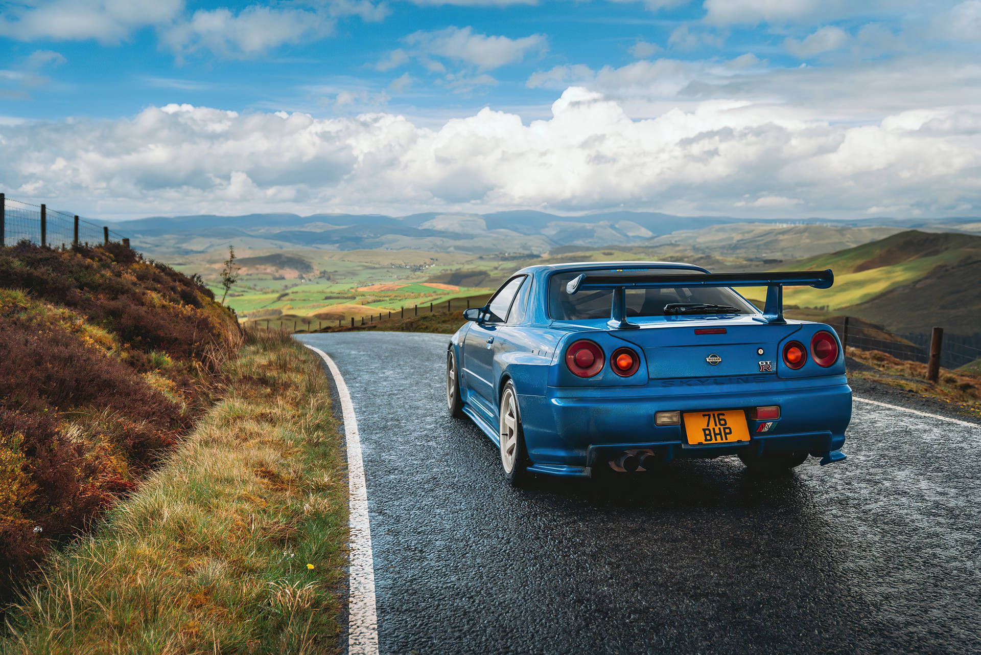 A blue car driving down the road - Nissan Skyline