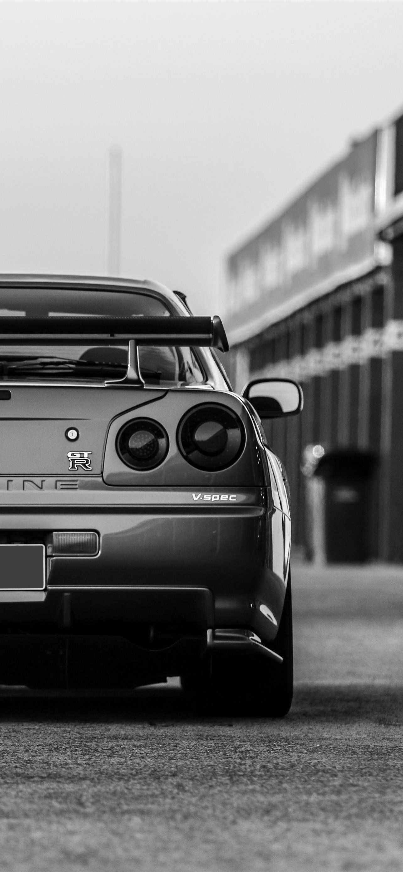 A black and white image of the rear of a Nissan Skyline R34 - Nissan Skyline