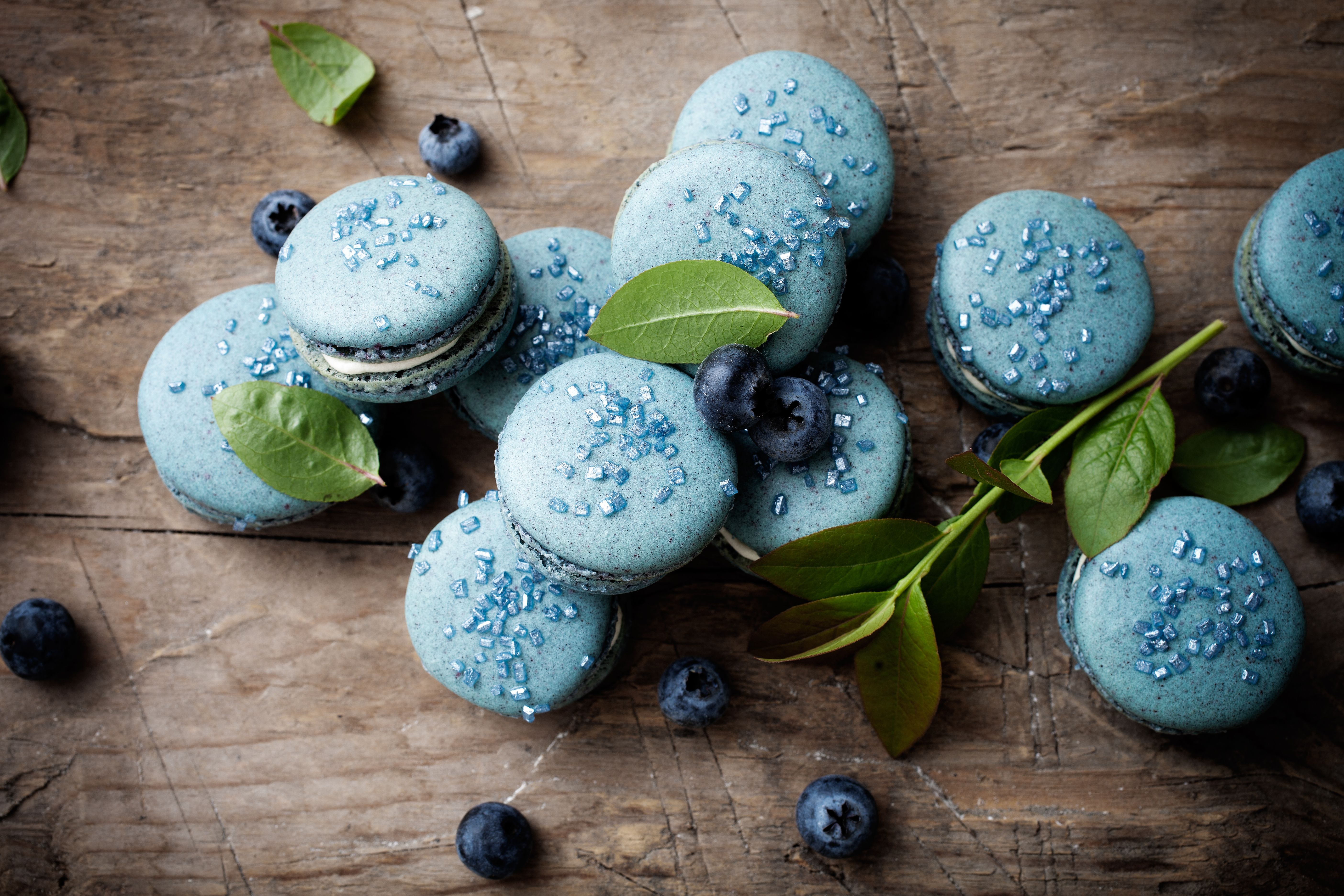 Blue macarons with blueberries on a wooden table - Macarons