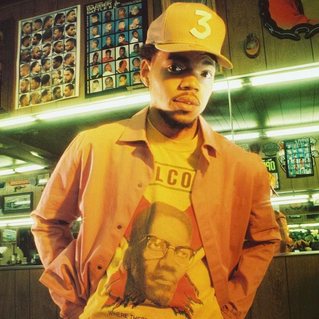A man standing in front of some posters - Chance the Rapper