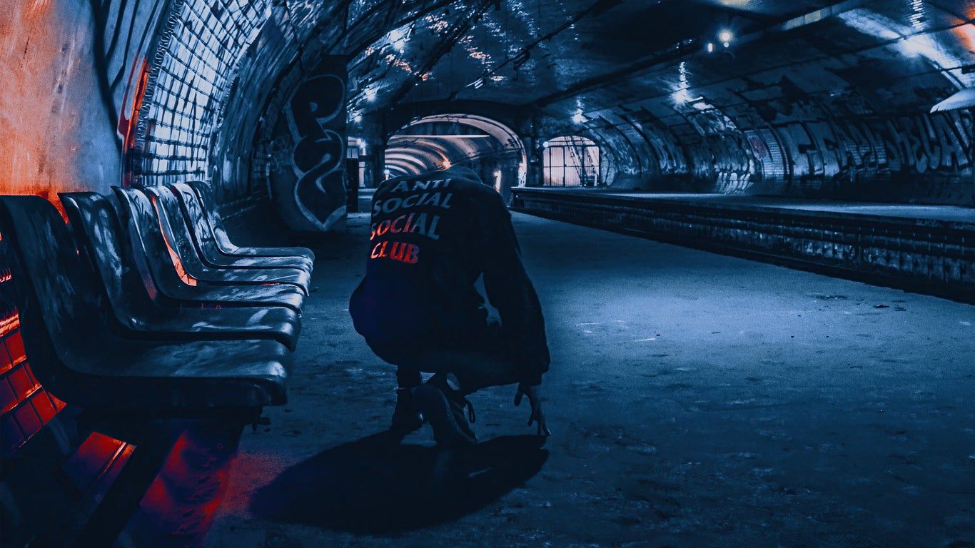 A person sitting on the floor in an underground tunnel - Anti Social Social Club