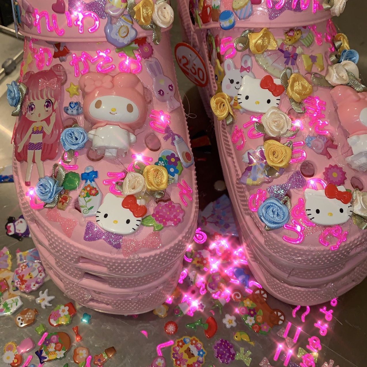 A pair of pink crocs covered in hello kitty decorations and lights - Webcore