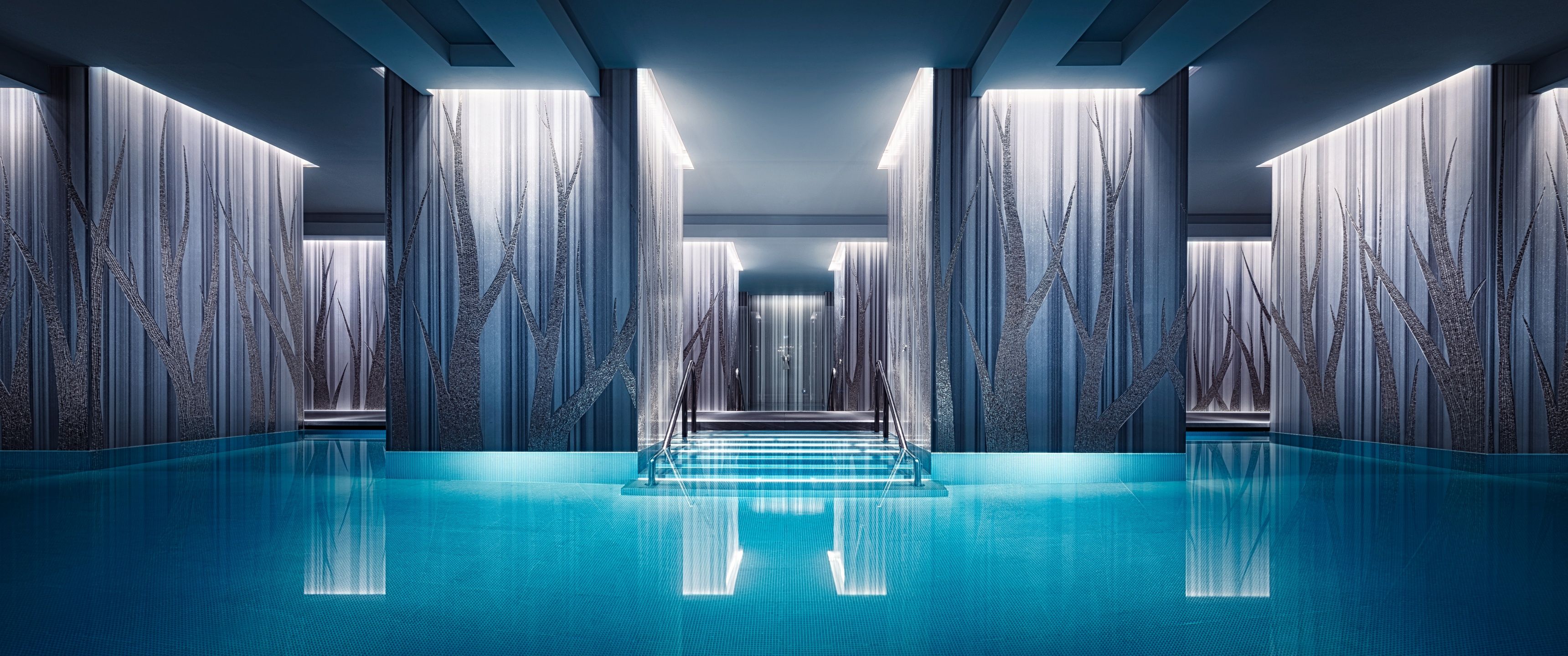 A long, narrow indoor swimming pool with waterfalls on the walls - Swimming pool